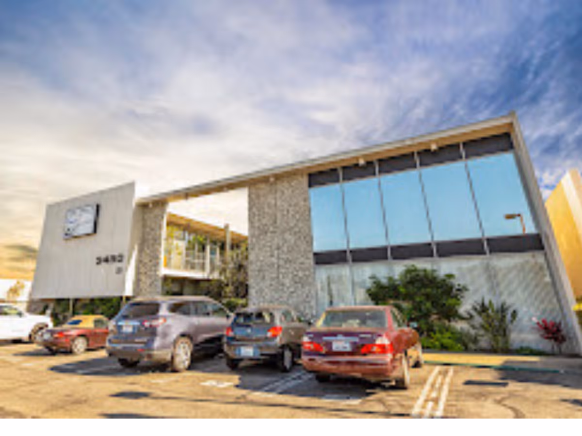Exterior of Senior Helpers of Long Beach building with parked cars and blue-tinted windows.
