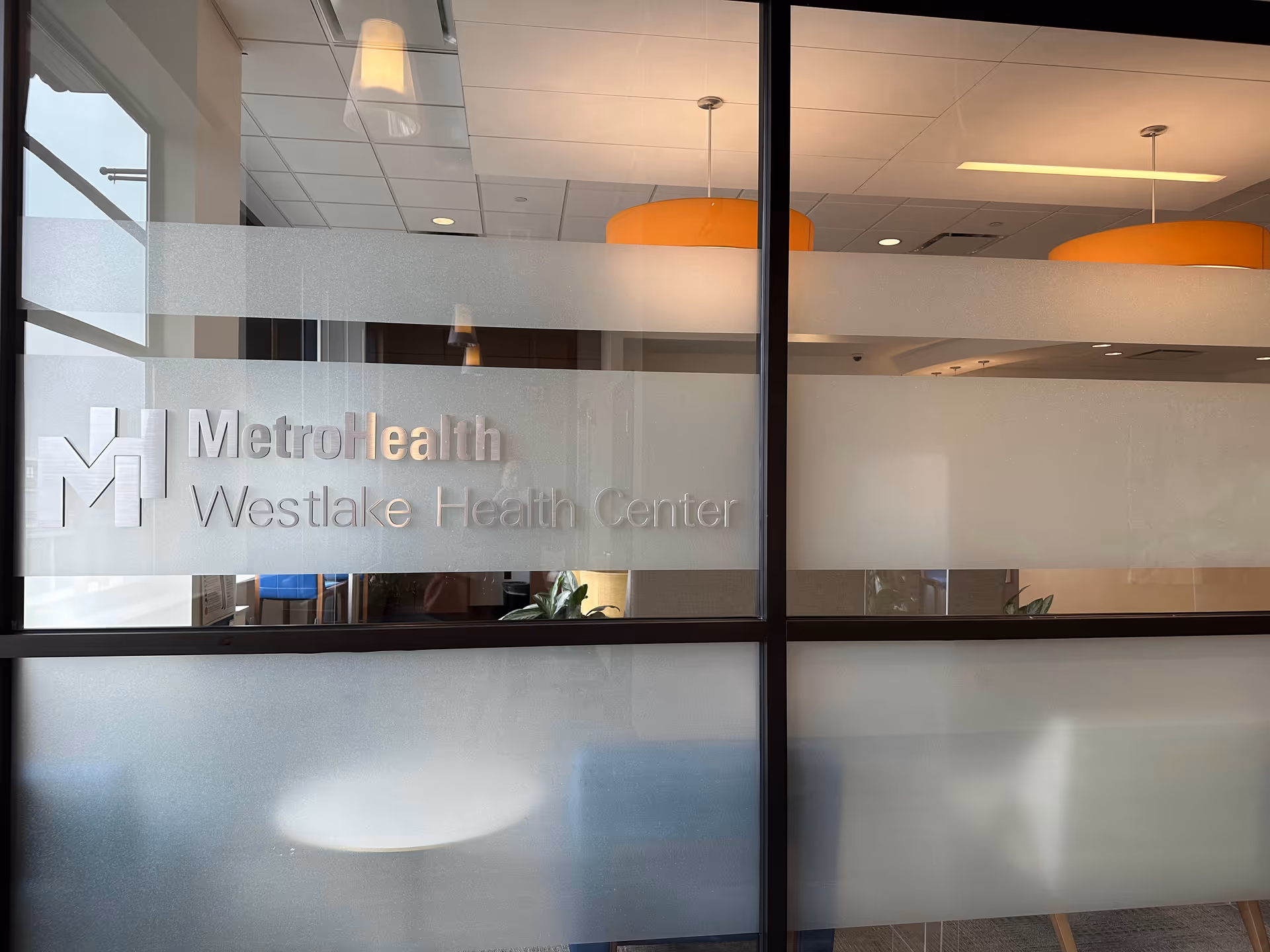 Glass wall displays MetroHealth Westlake Health Center signage inside a modern lobby.