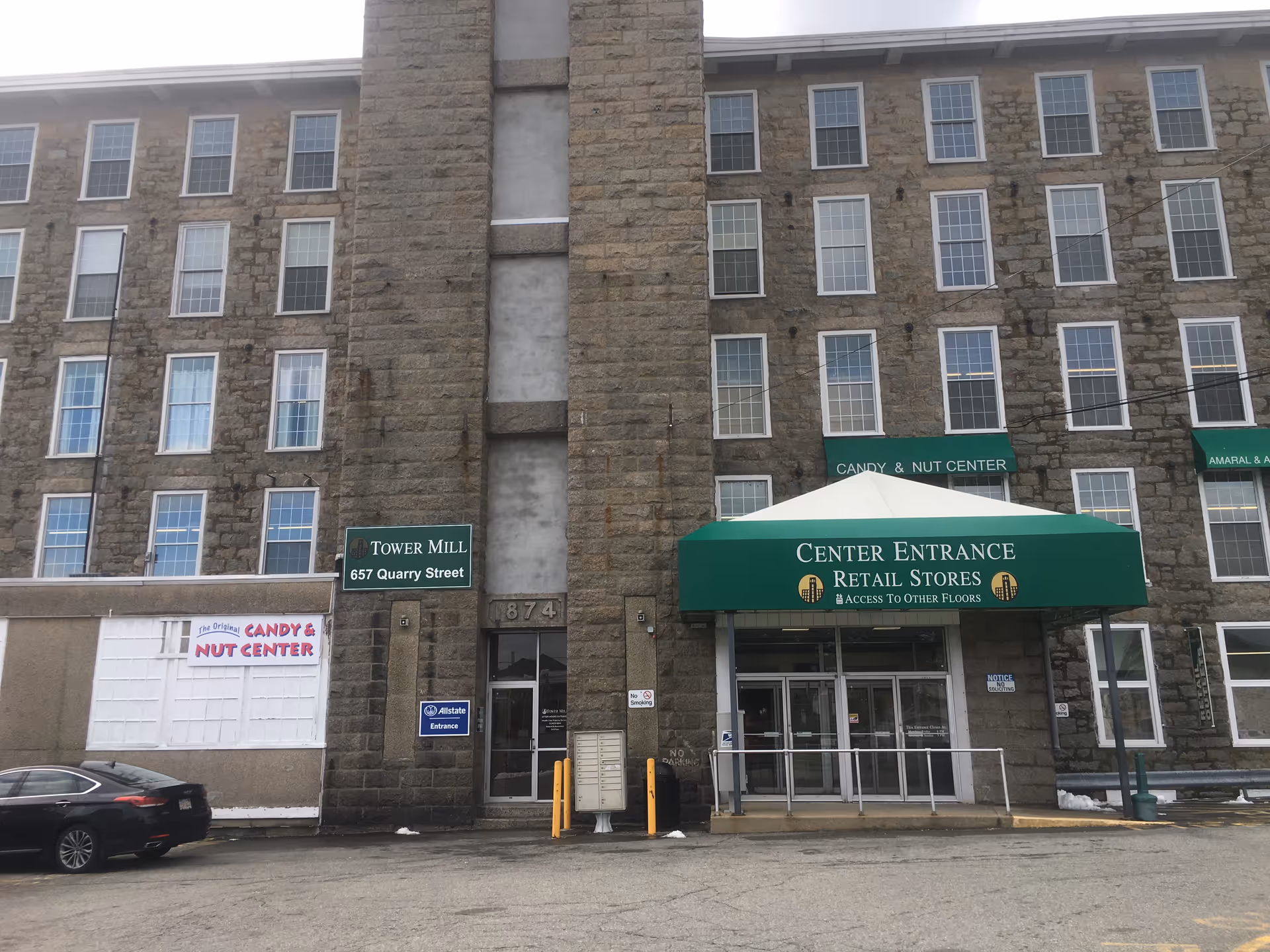 Stone building facade with numerous windows and a green awning over the center entrance.