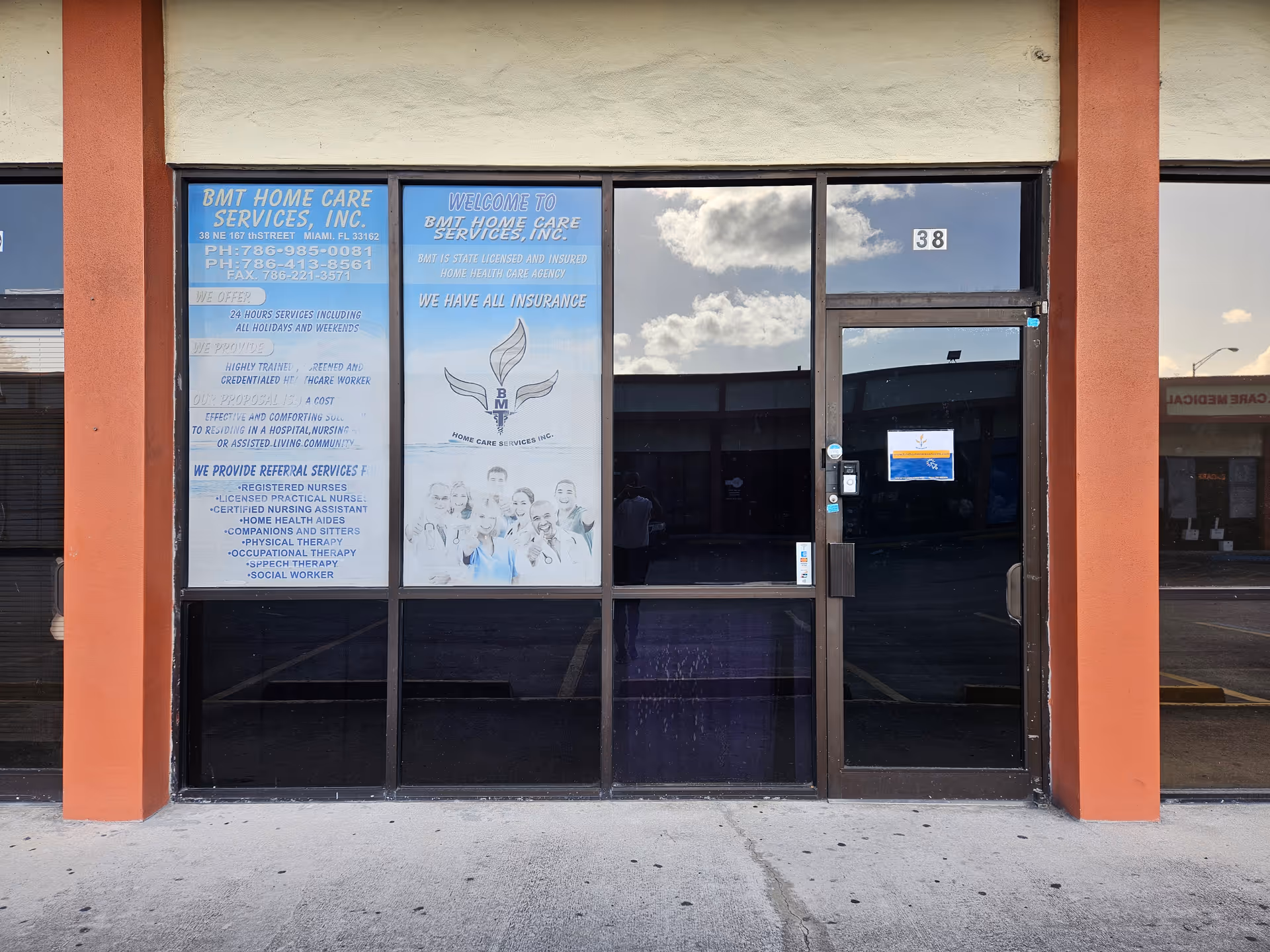 Exterior of a facility with glass doors and signs for BMT Home Care Services.