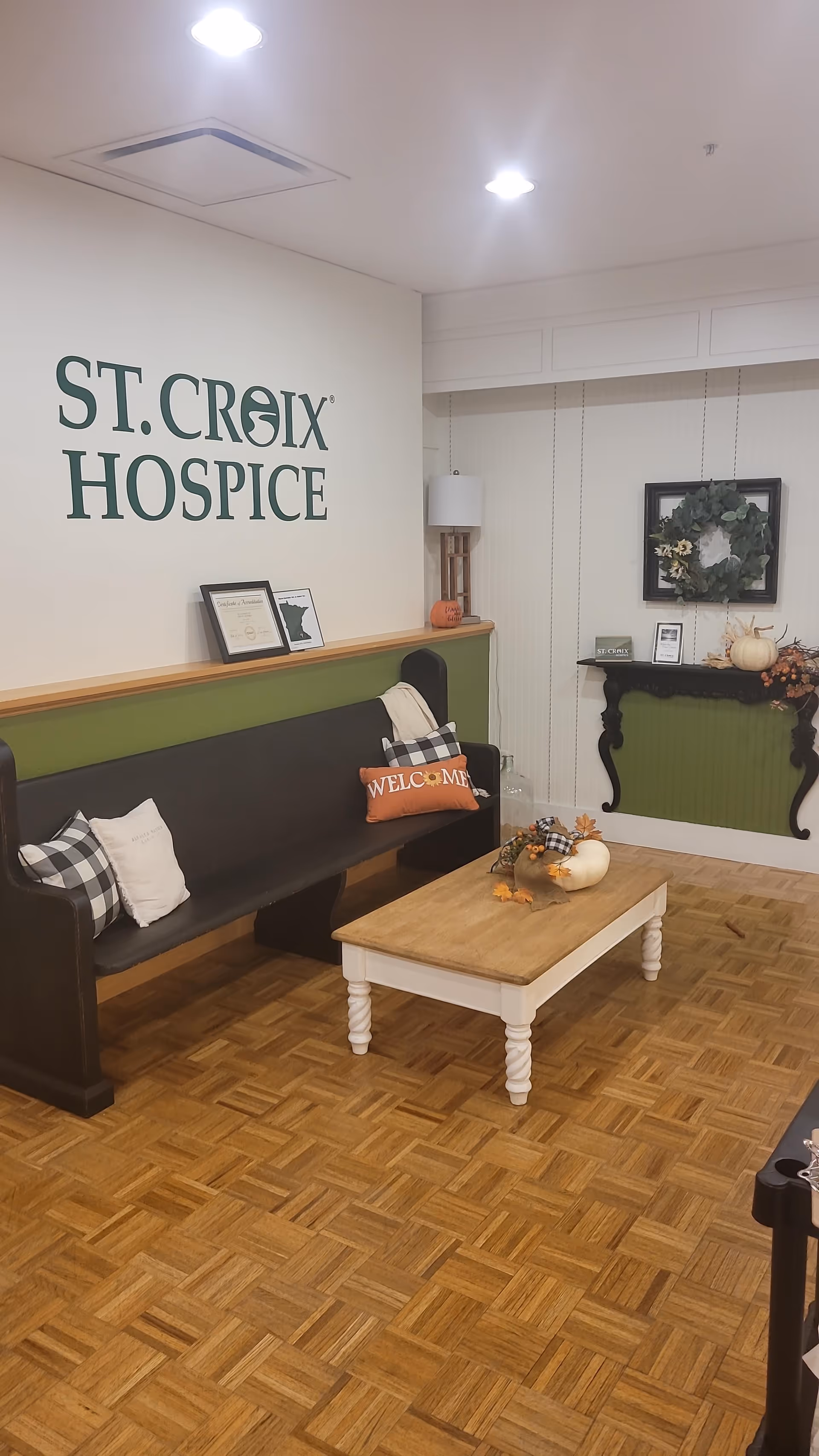 Lobby seating area with a St. Croix Hospice sign and fall decor.