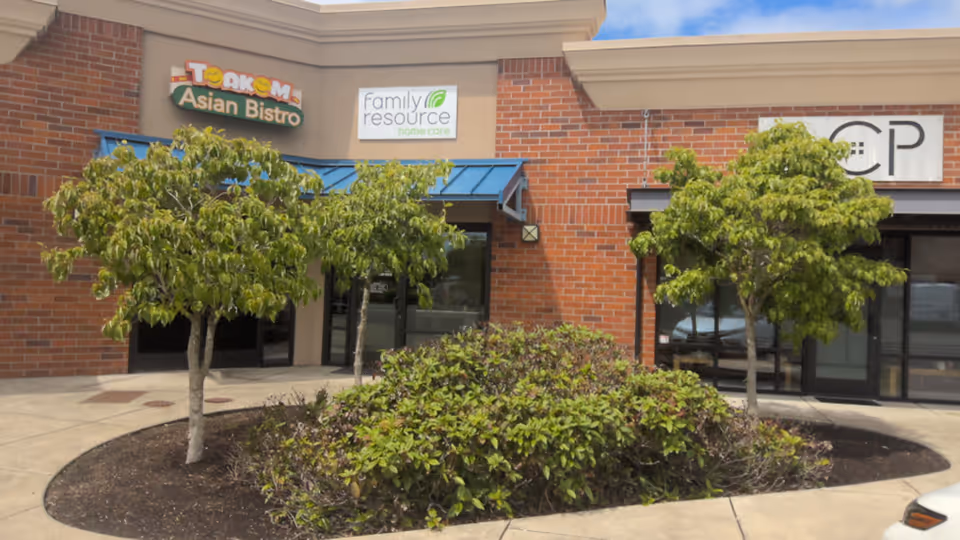 Exterior view of a brick storefront with Family Resource Home Care sign and landscaping.