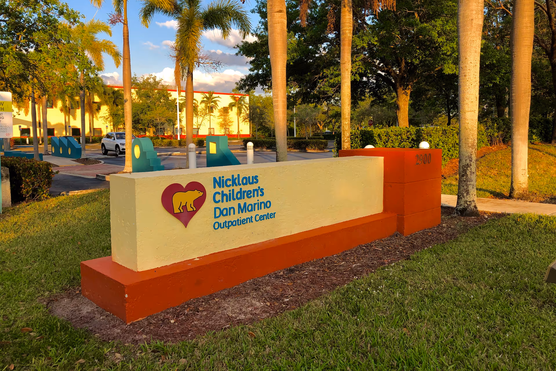 Outdoor entrance sign for Nicklaus Children's Dan Marino Outpatient Center with palm trees.
