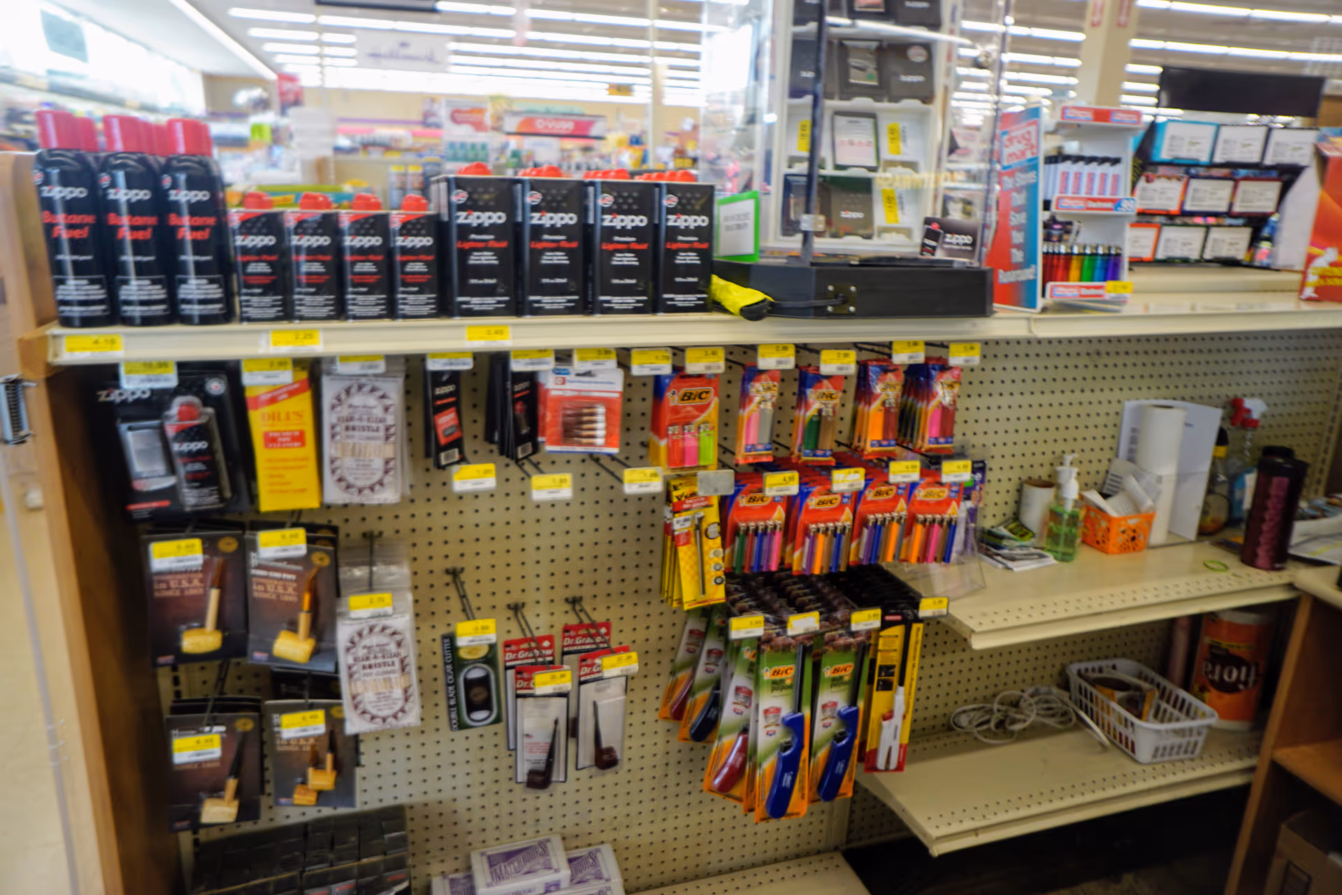 A store shelf displays assorted drugstore items and supplies in a busy aisle.