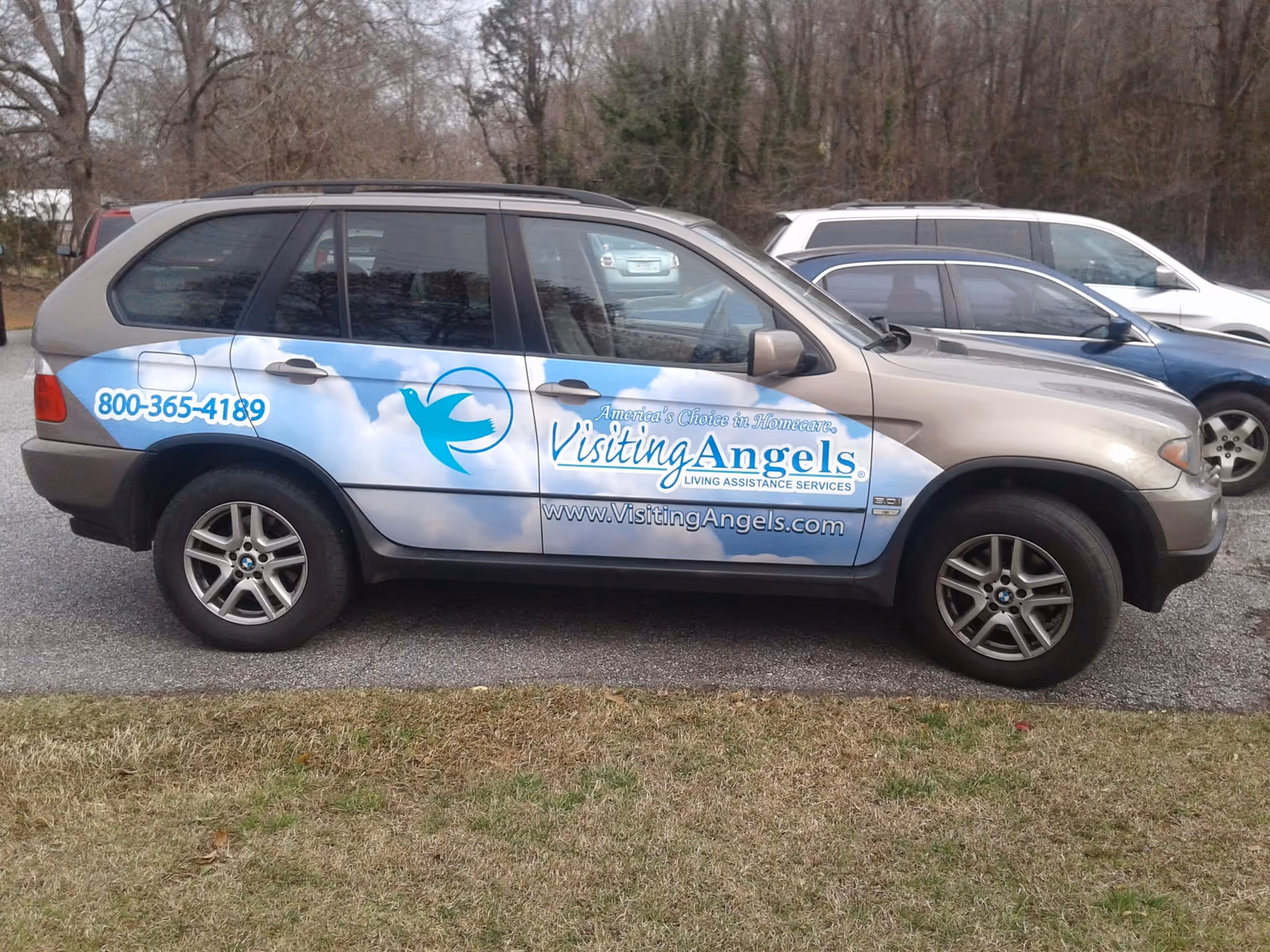 A Visiting Angels promotional van parked in a parking lot.