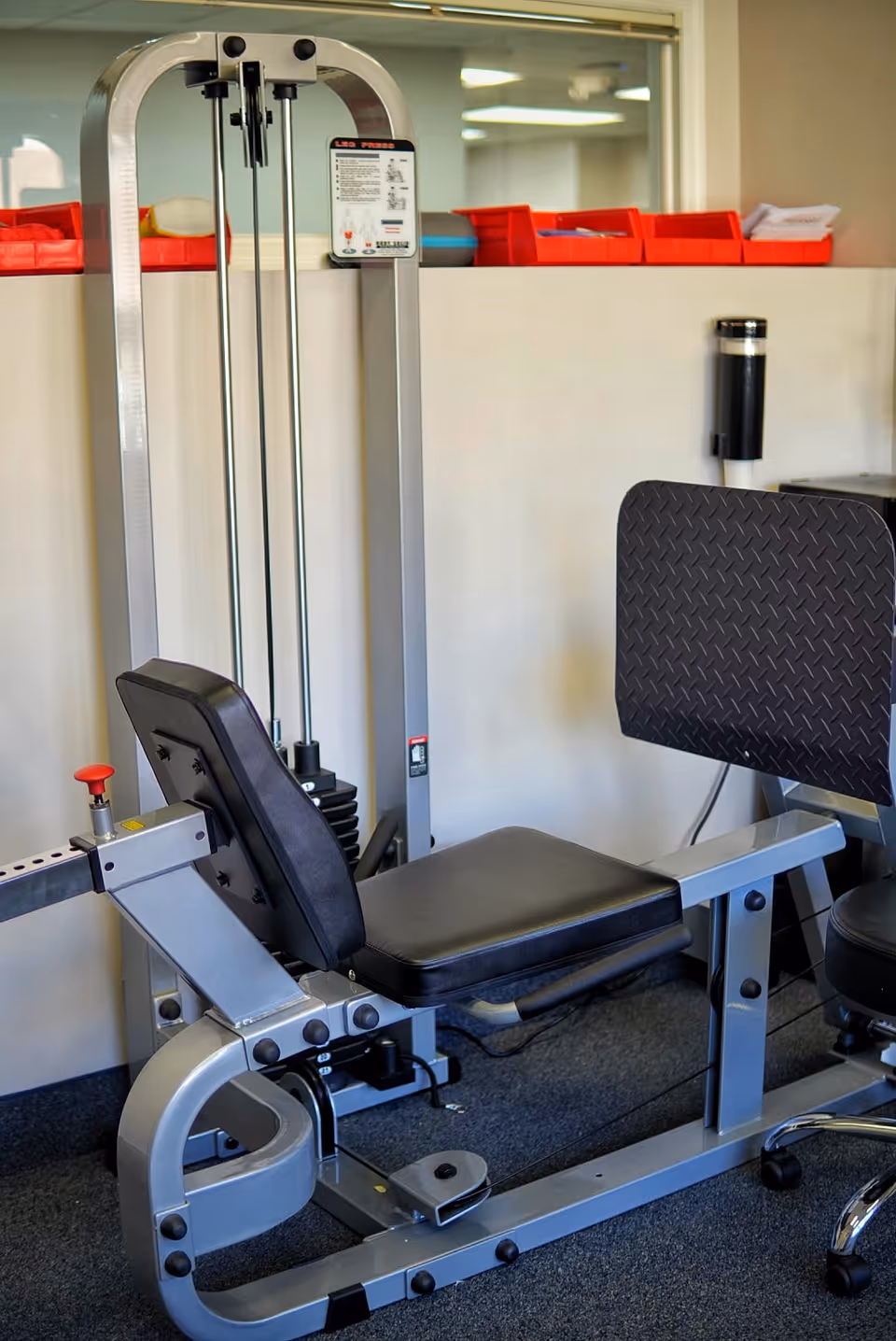 Leg extension exercise machine in a senior living facility gym.