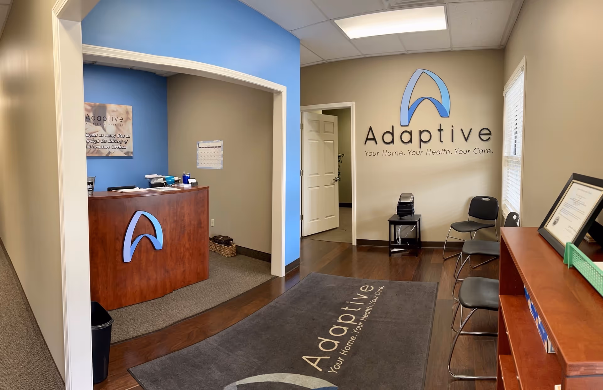 Reception desk with Adaptive logo wall in care facility lobby.