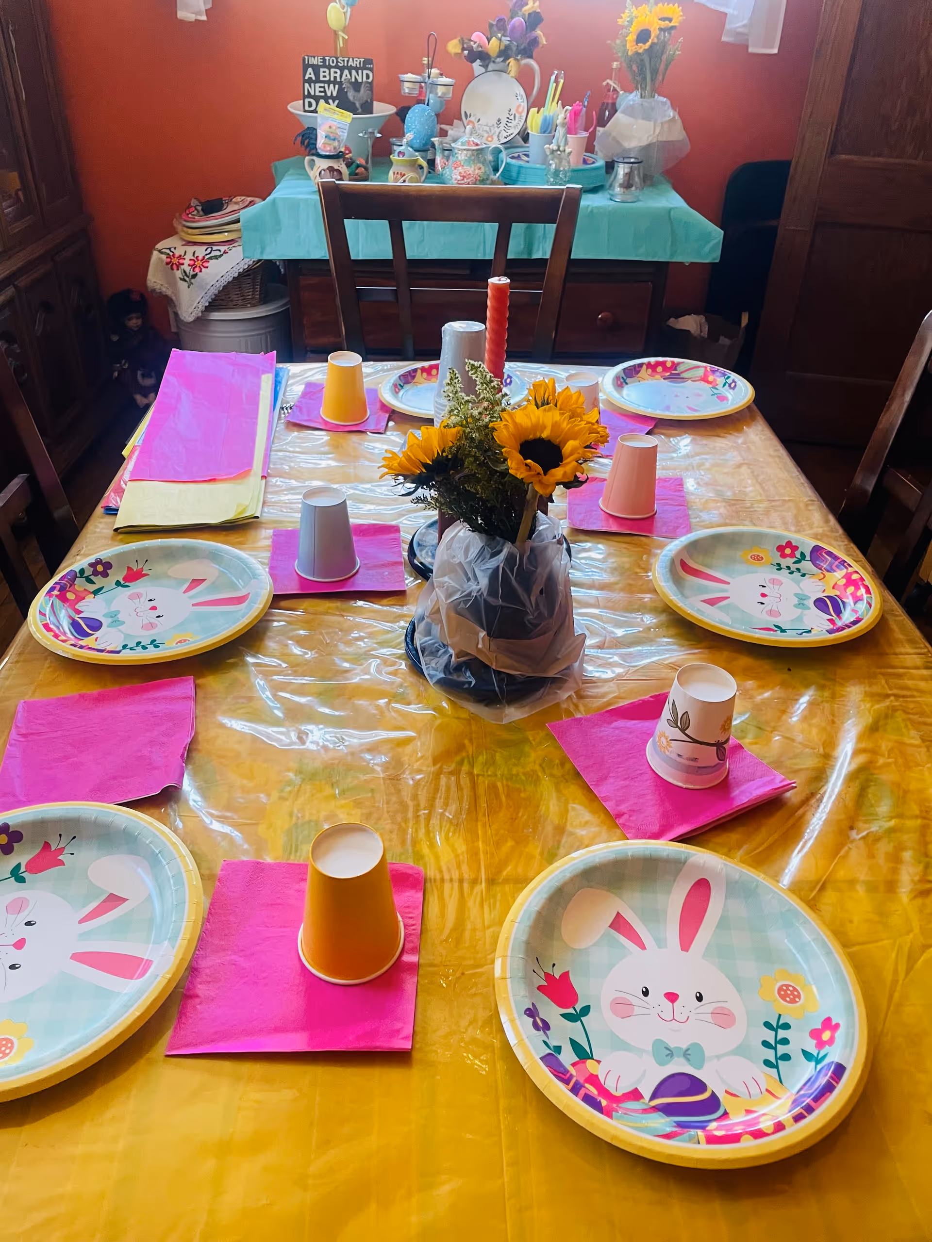 Colorful Easter-themed dining table with bunny plates and sunflowers in a care facility.