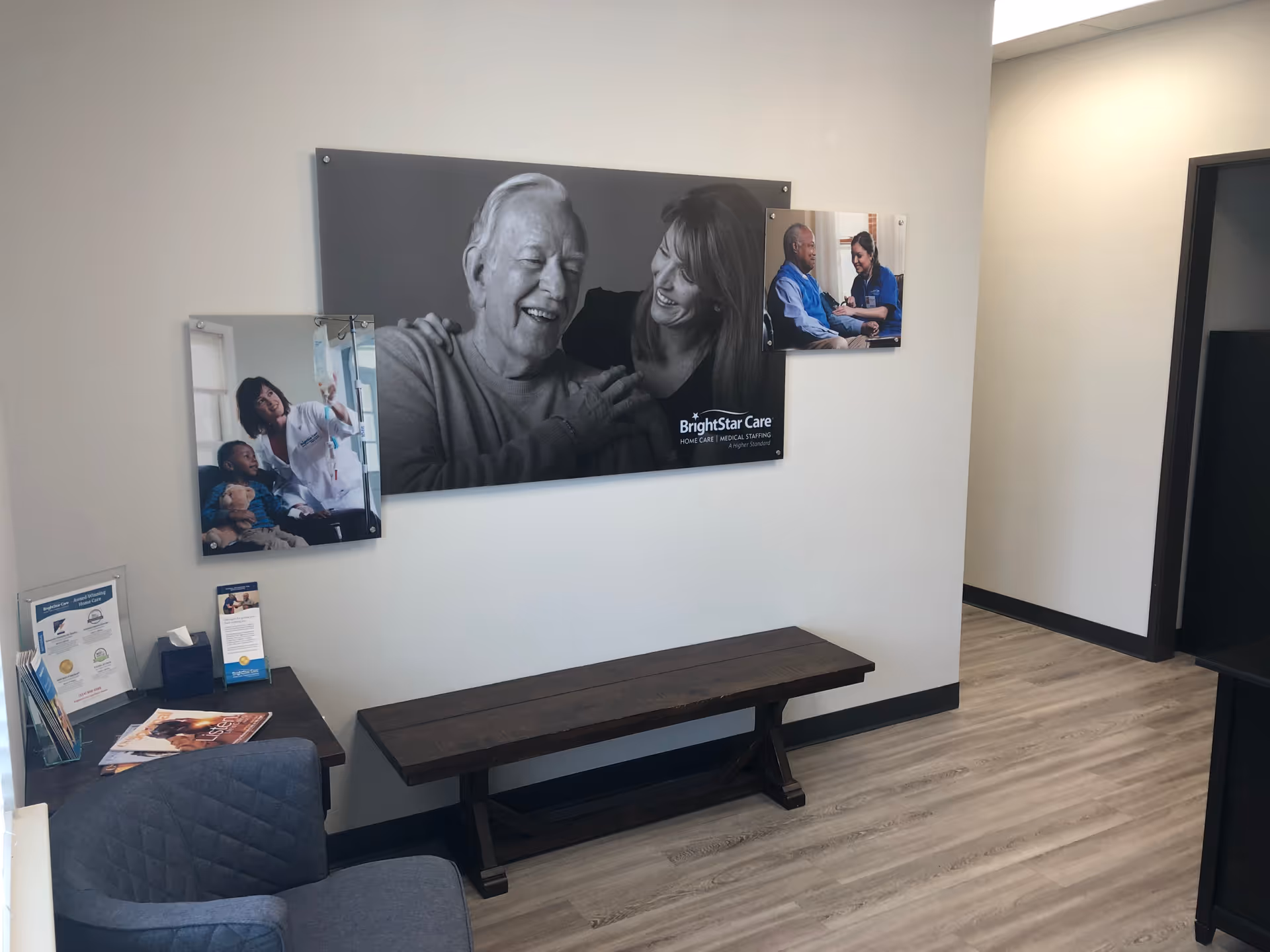 Lobby area with wall-mounted BrightStar Care photos, a bench, and pamphlet stand.