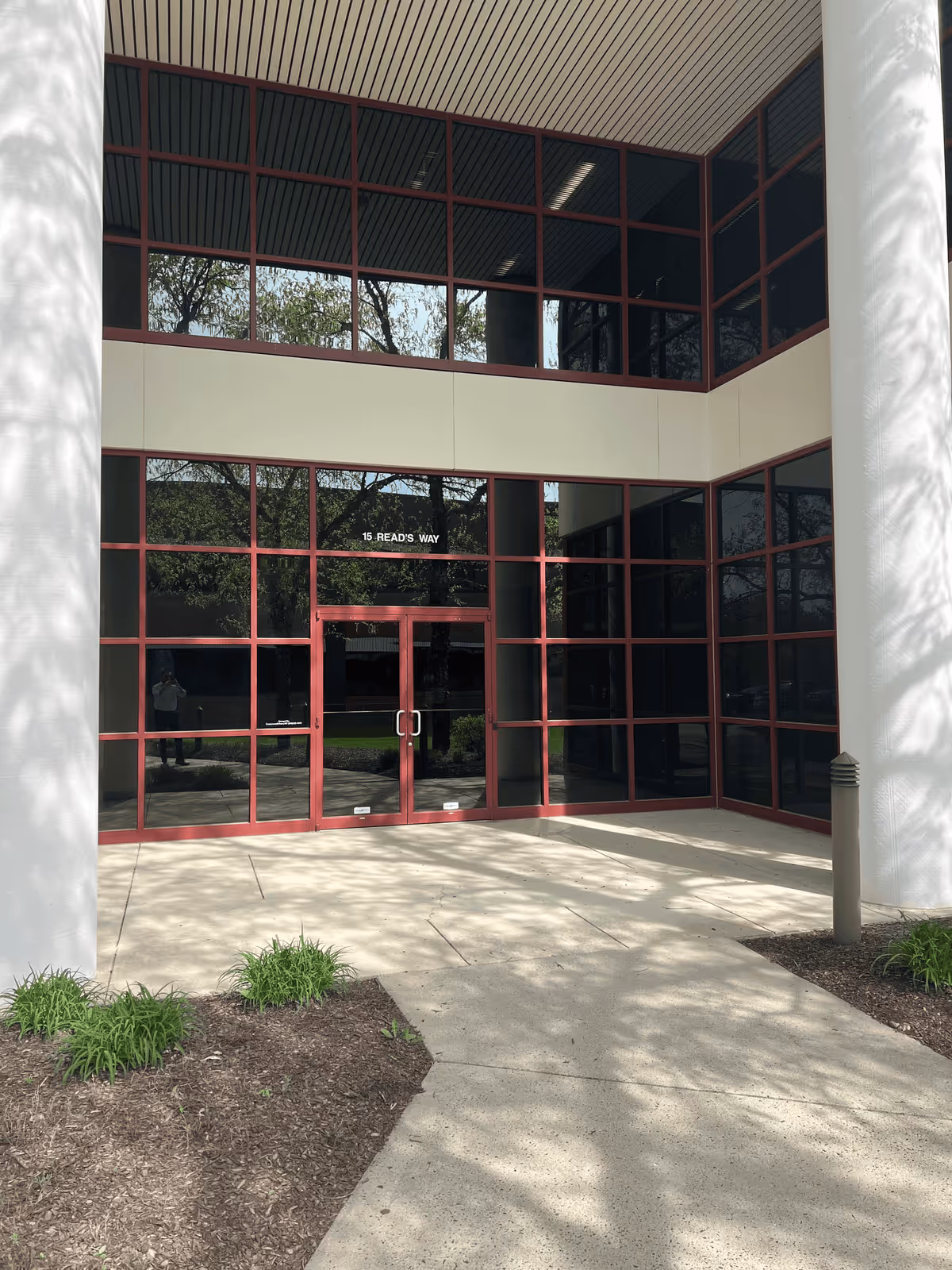 Glass-front entrance with red-framed doors and large windows at the building exterior.