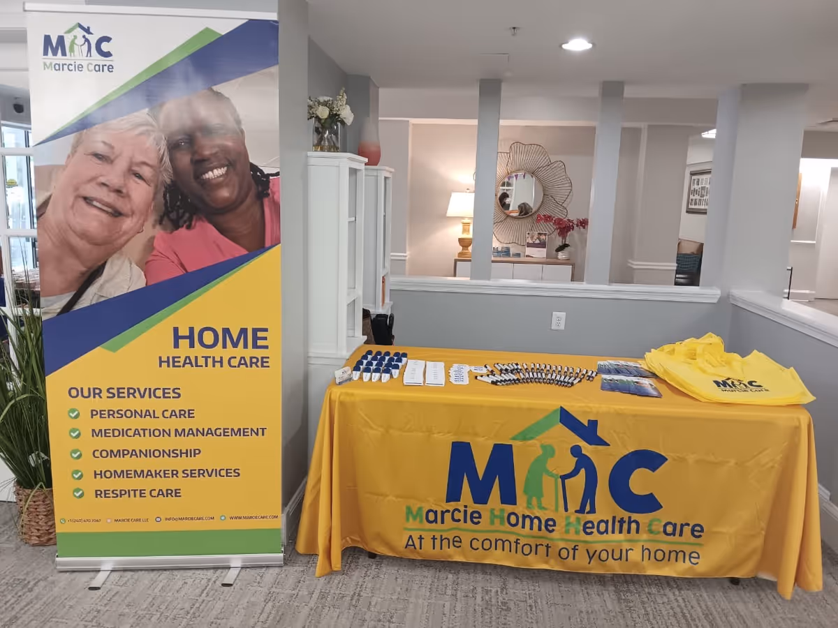Indoor lobby area with a yellow promotional table and Marcie banner.
