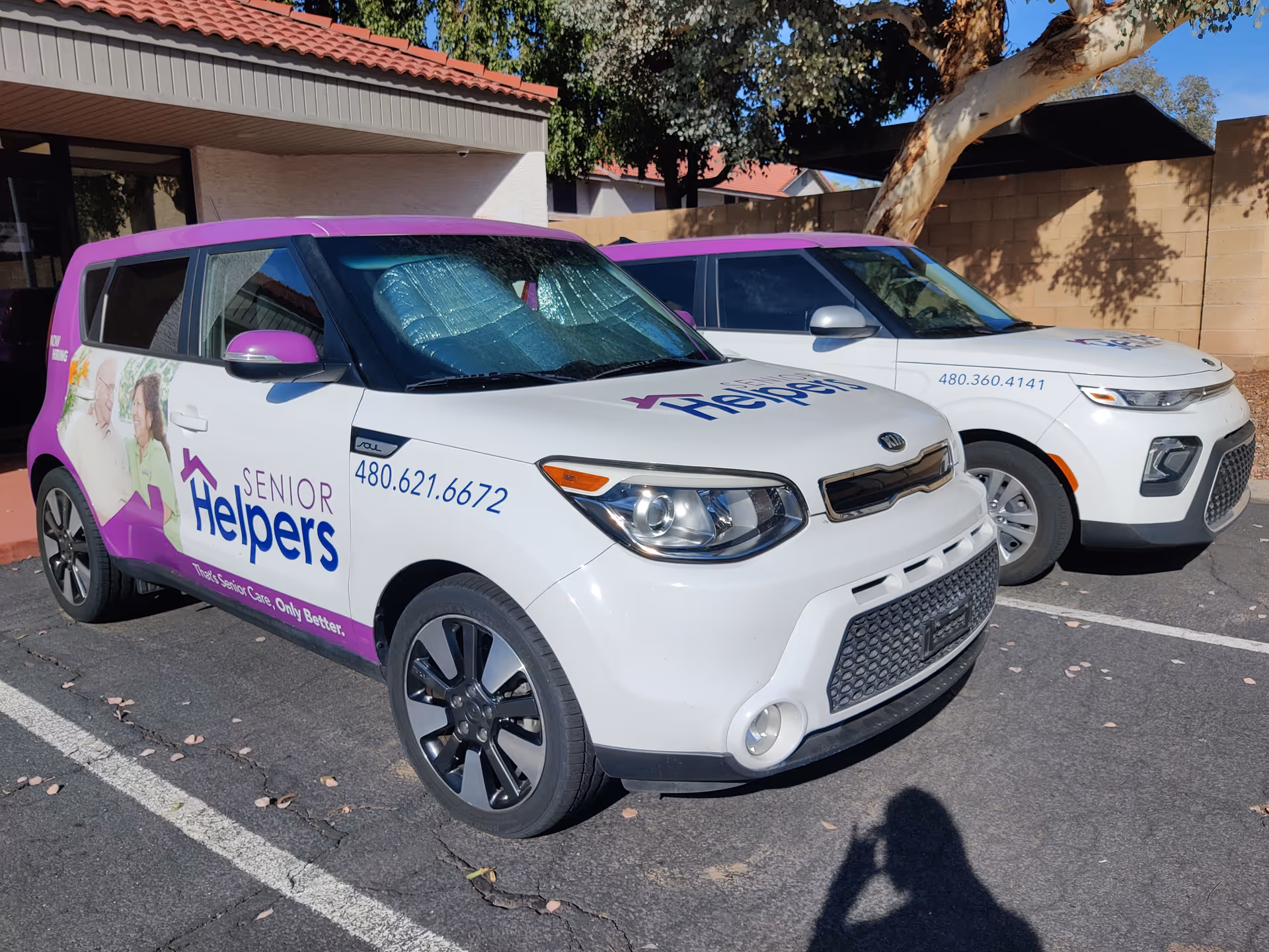 Two Senior Helpers branded vehicles parked outside a facility.