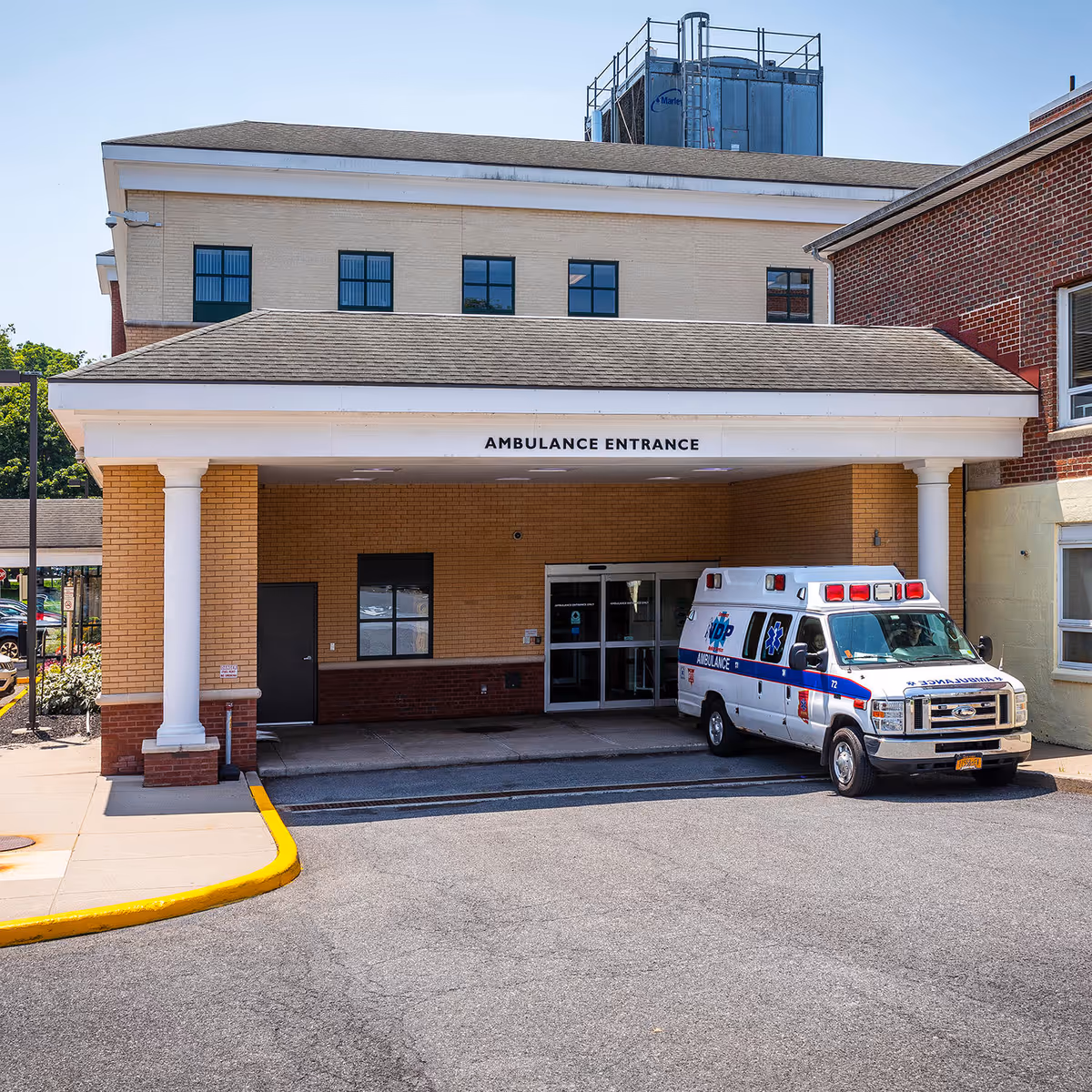 Exterior of the facility with an ambulance parked at the ambulance entrance.