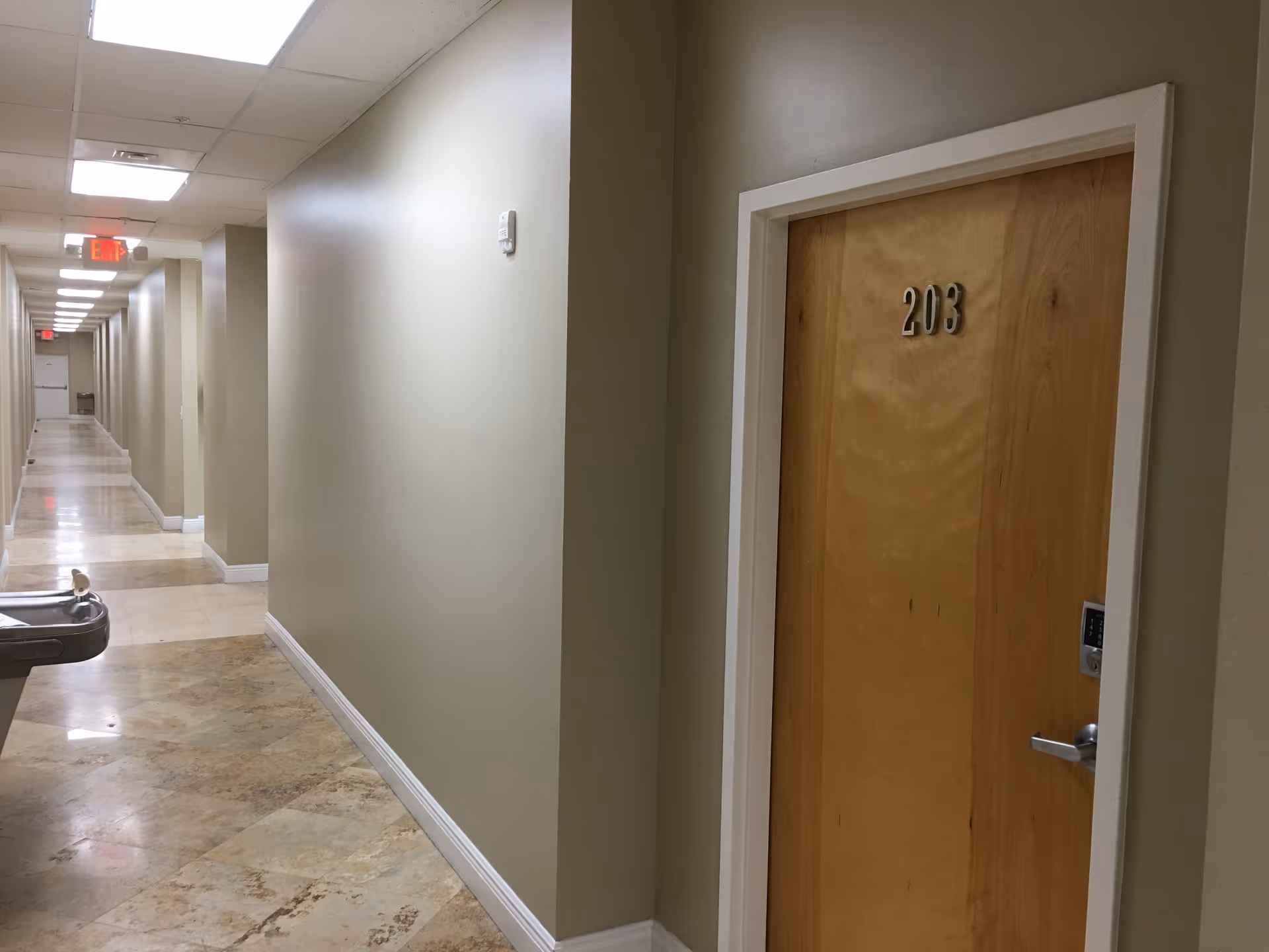 Interior corridor of a senior living facility with door 203.