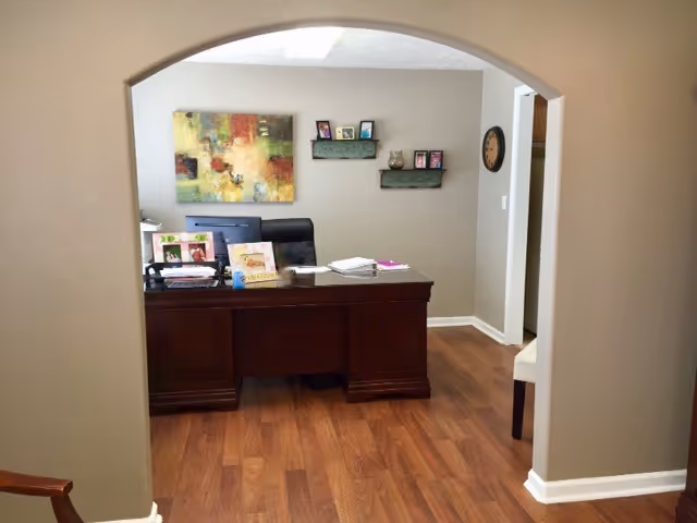 Reception desk in a warmly lit office with wood floors and wall art.