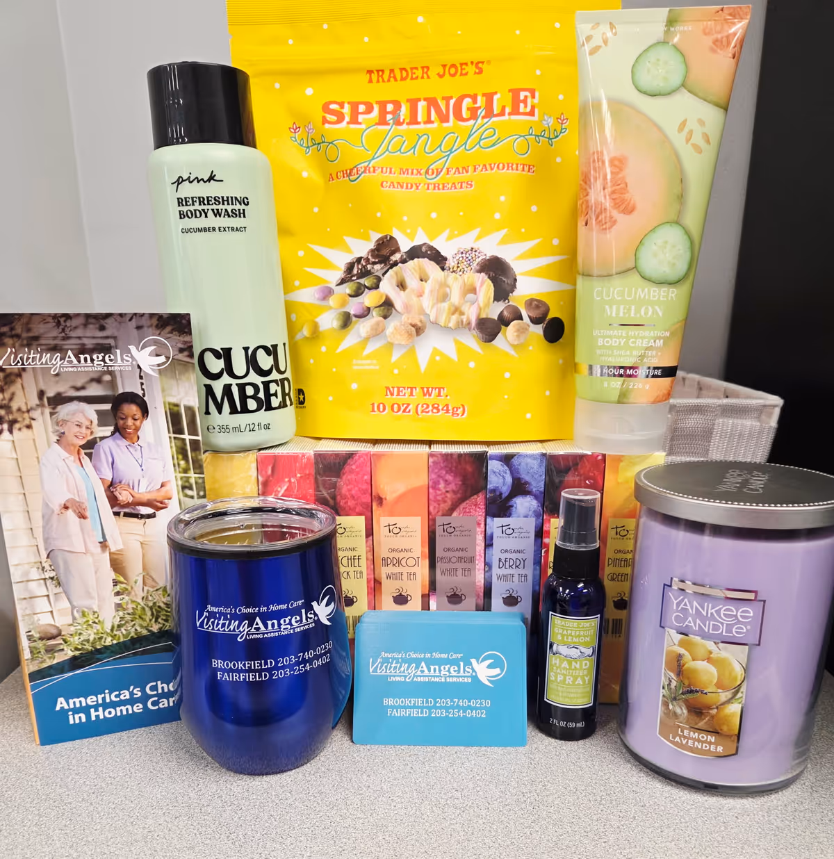 A desk display of Visiting Angels promotional items, candles, and care brochures.