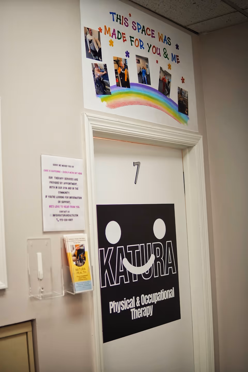 Corridor wall featuring a door to Katura Physical and Occupational Therapy with a colorful sign above