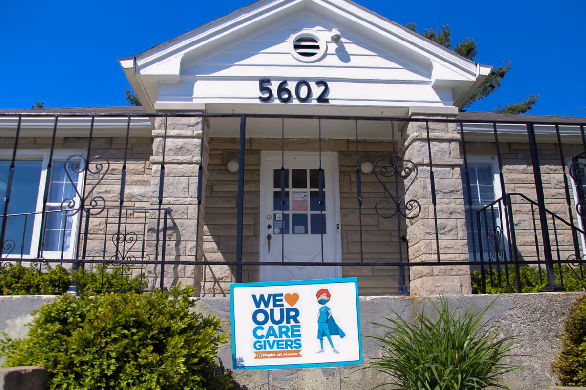 Front view of a Right at Home senior facility with stone facade and railing.