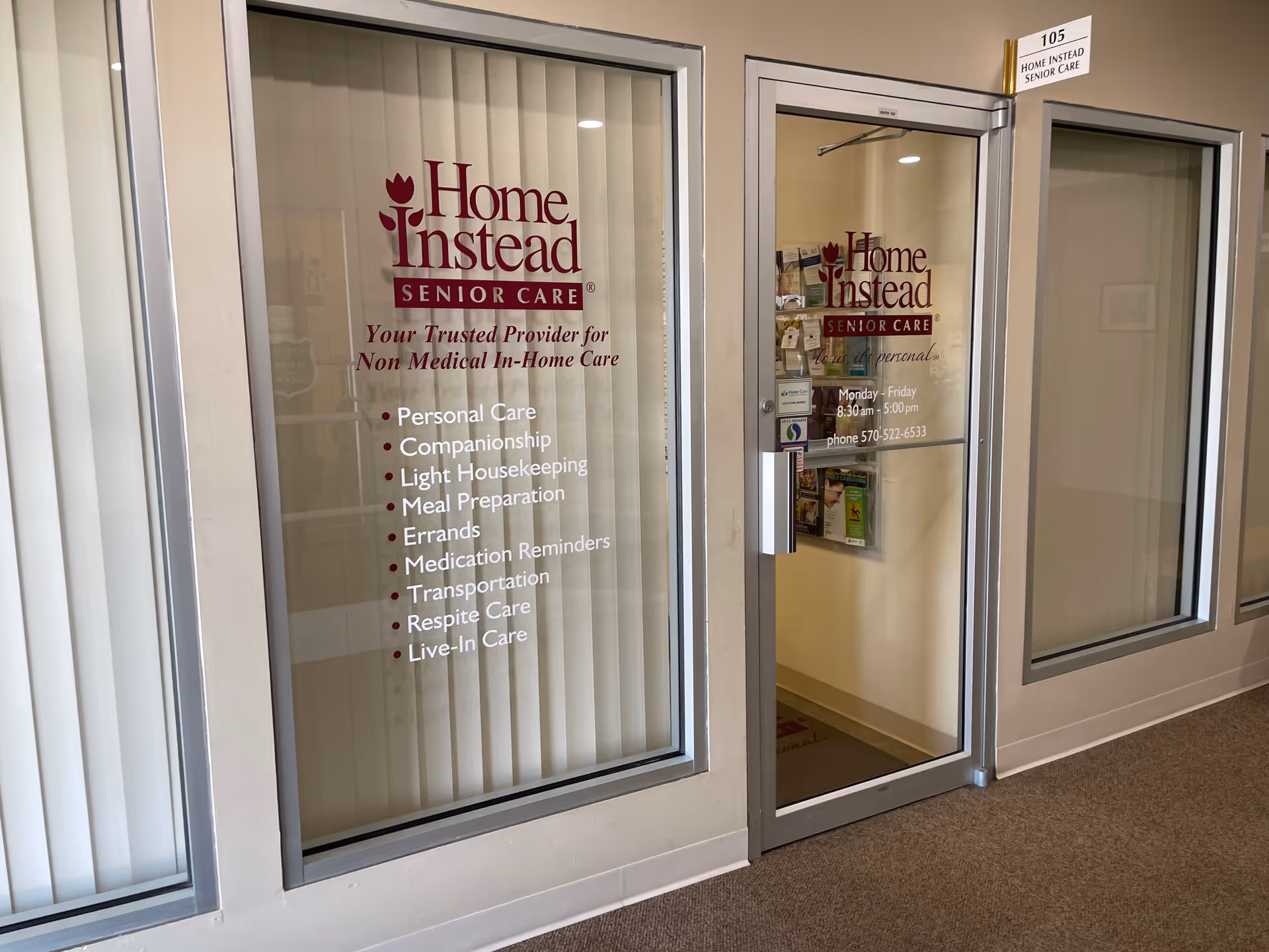 Entrance to Home Instead Senior Care with glass doors displaying signs and a bullet list.
