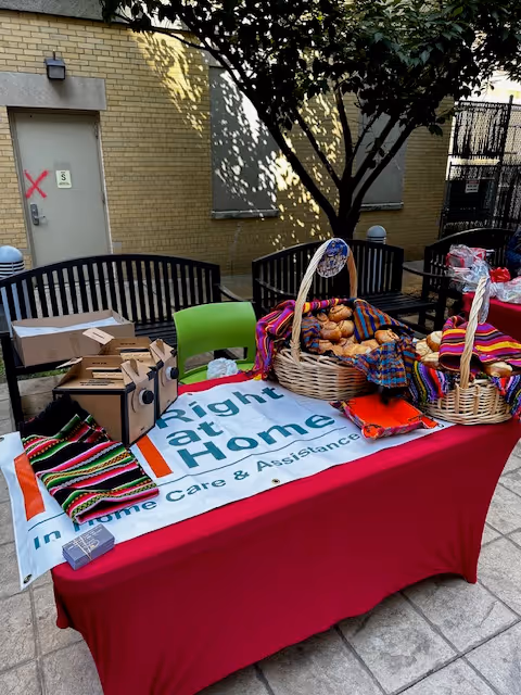 Outdoor table setup with bread baskets and boxes beside a Right at Home banner.