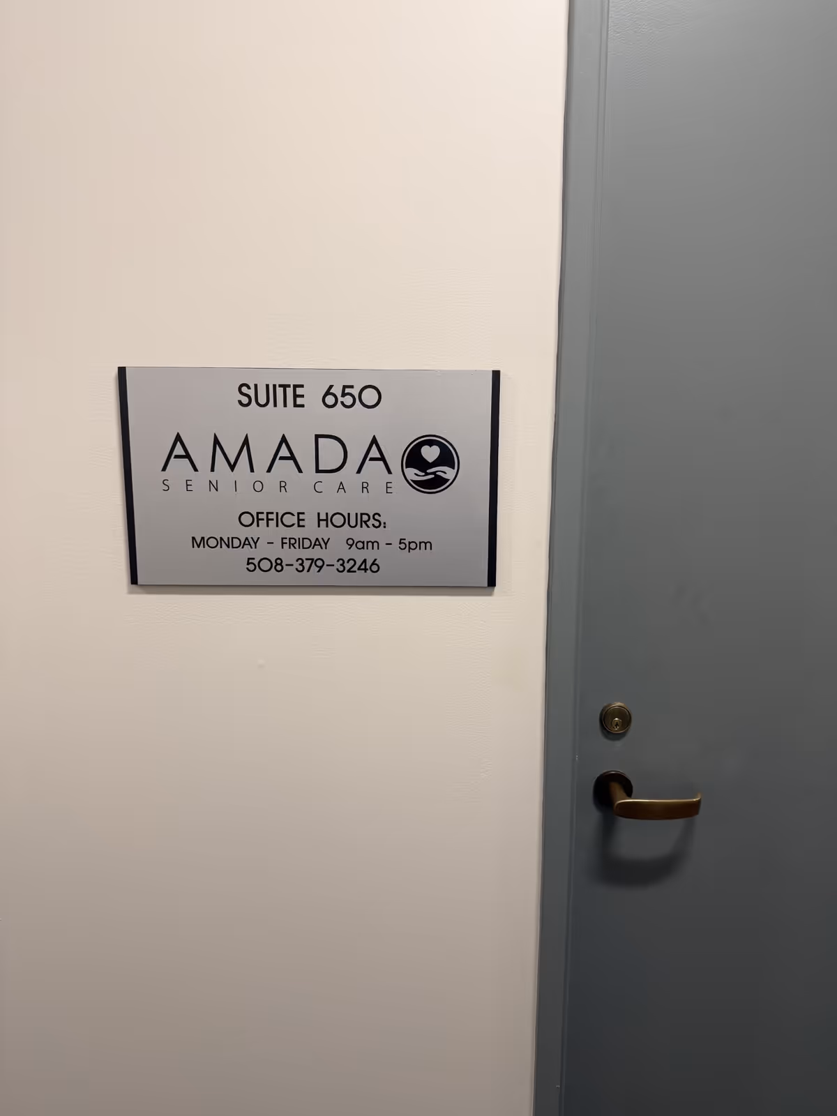 Interior wall sign for Suite 650 Amada Senior Care beside a gray door