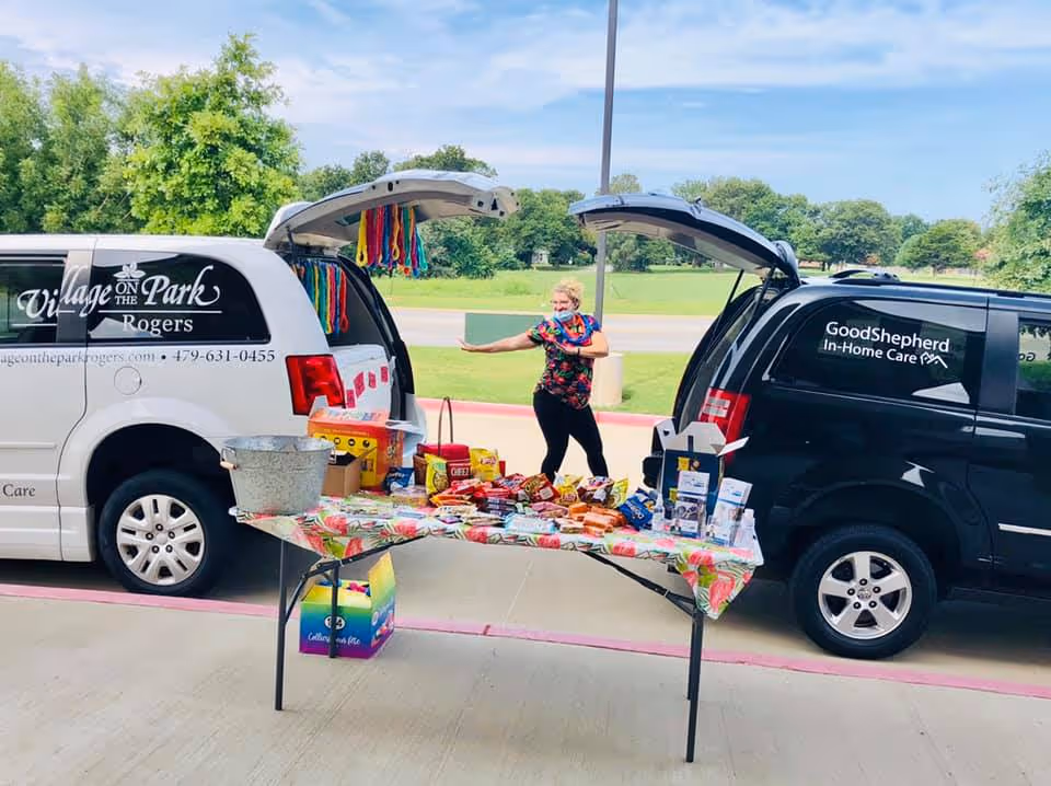 Outdoor scene with two vans, a snack table, and a person nearby.
