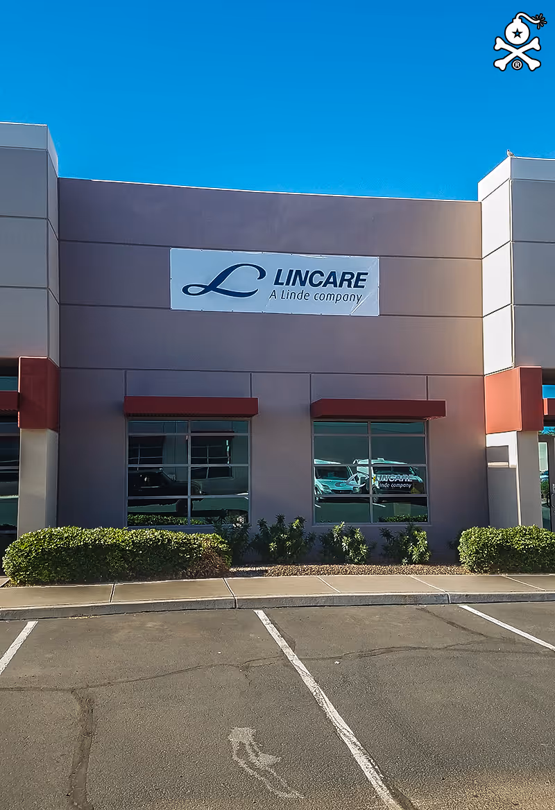 Exterior view of a LINCARE building with sign, windows, shrubs, and a parking lot.