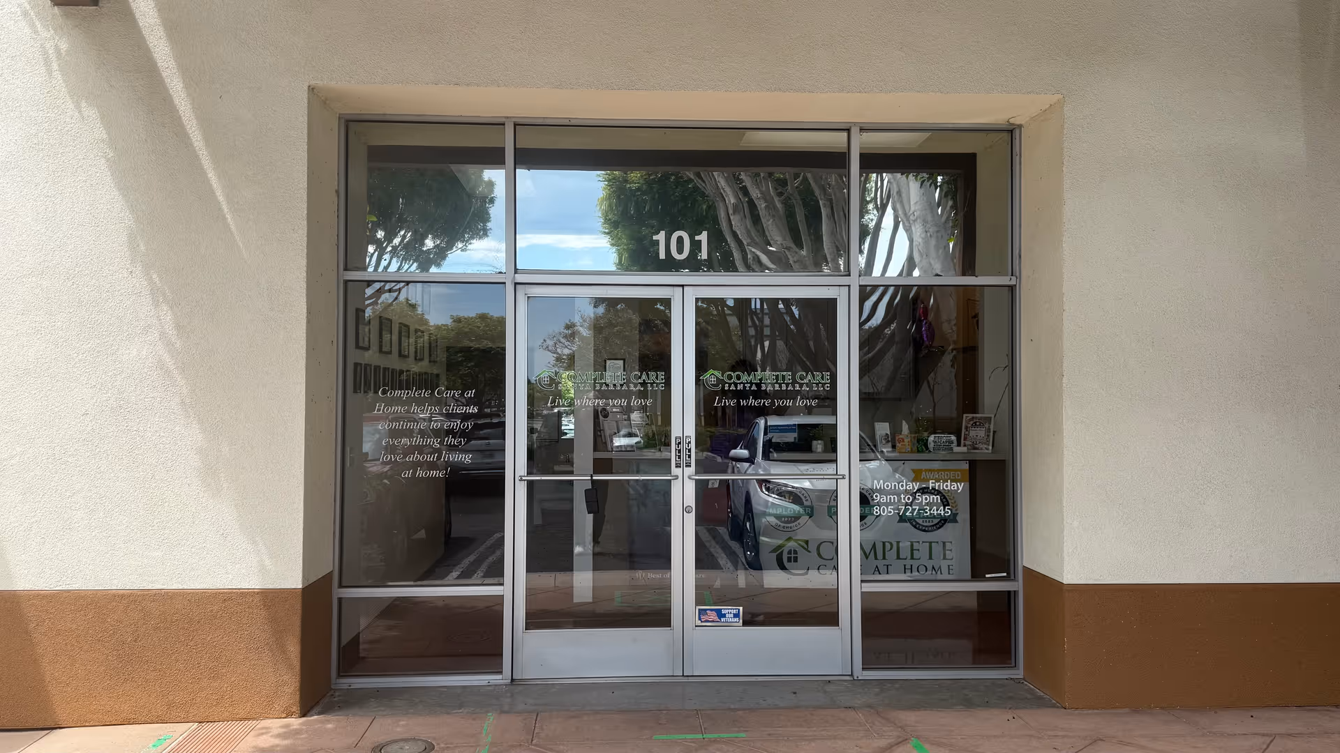 Glass storefront door with 'Complete Care at Home' logo, building facade, 101 above door.