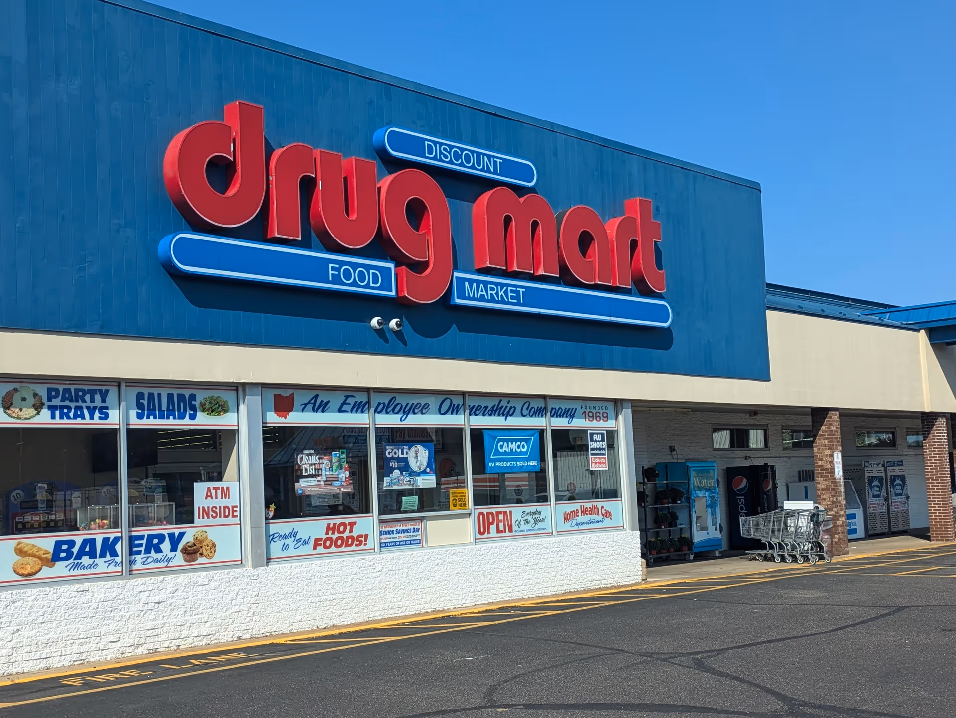 Front view of Discount Drug Mart storefront with a large red sign