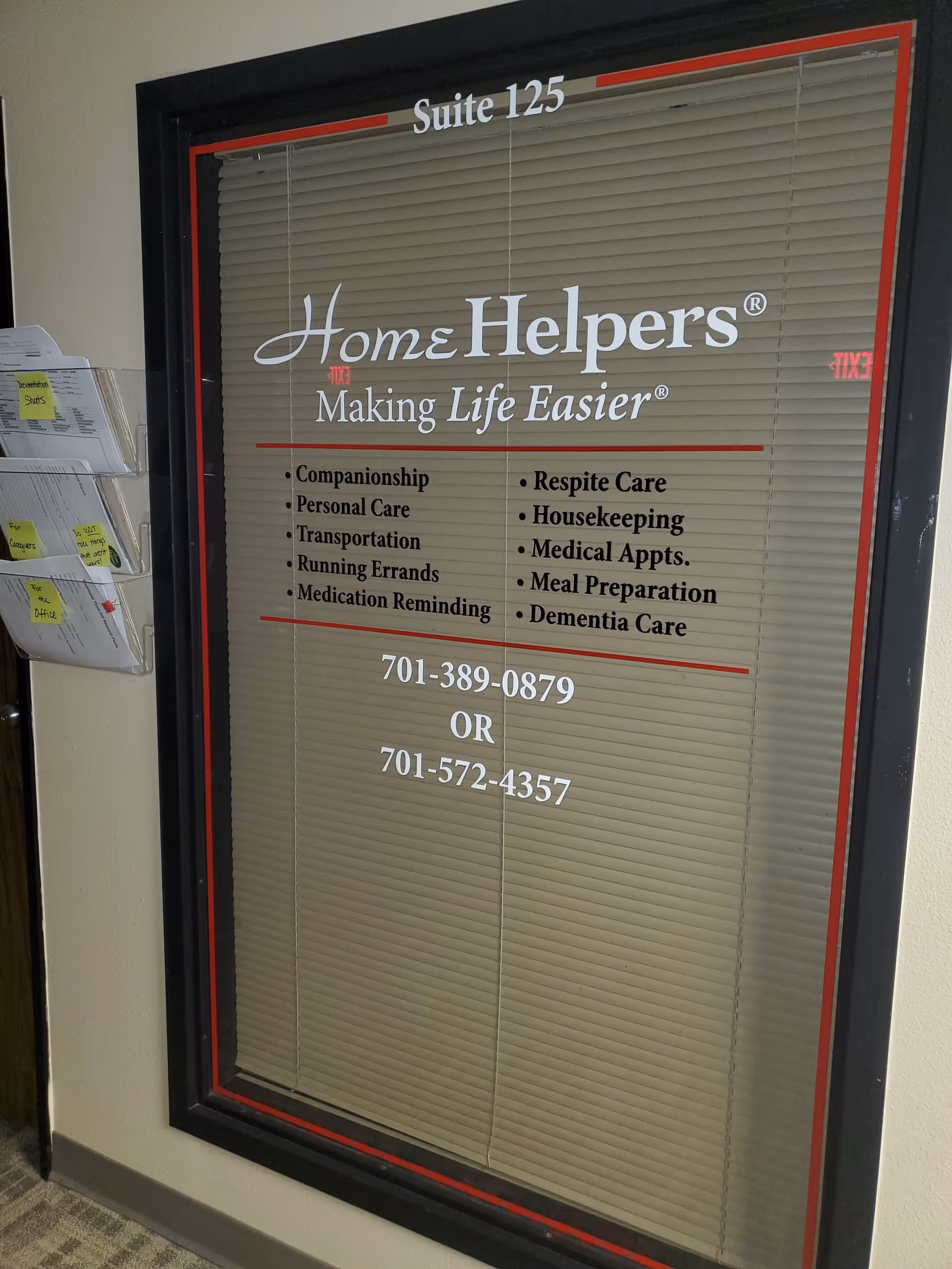 Framed glass panel in hallway displaying Home Helpers Suite 125 and services.