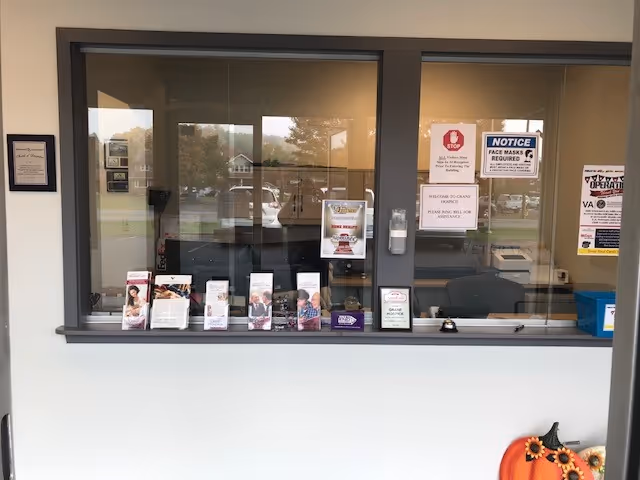Reception window with brochures and notices inside a senior care facility lobby.