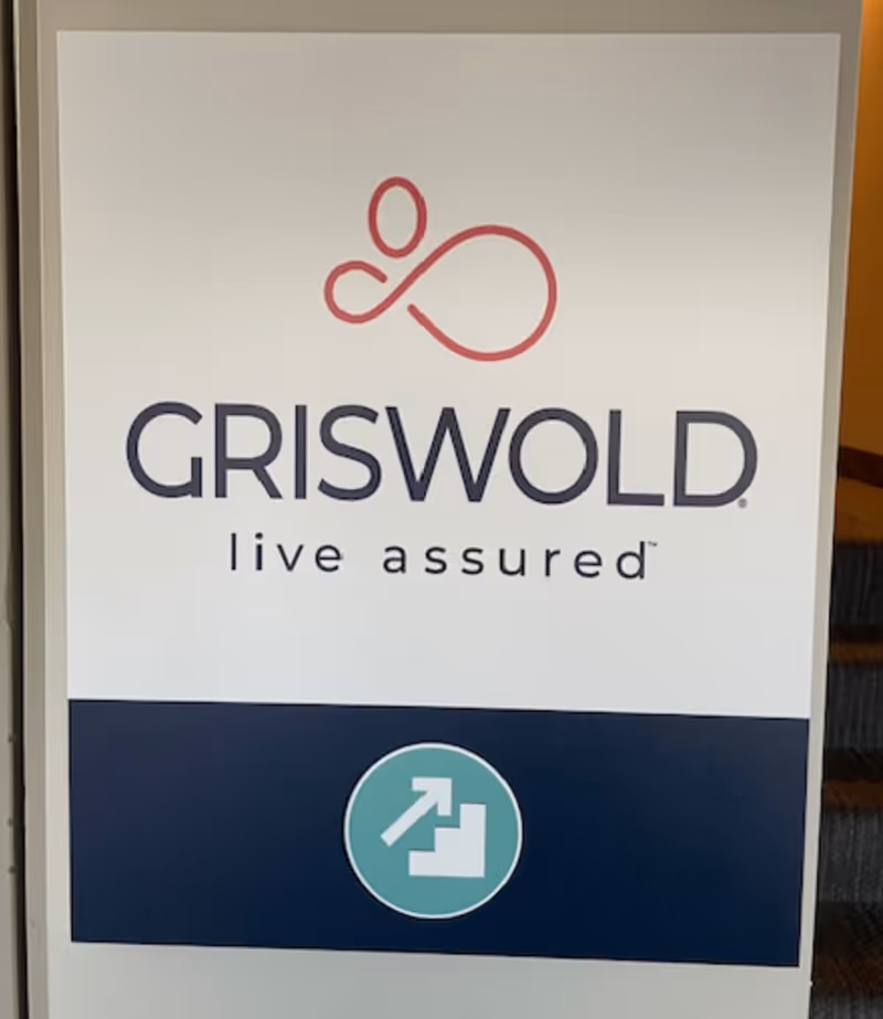 Griswold sign with logo, 'live assured' text, and an exit icon.