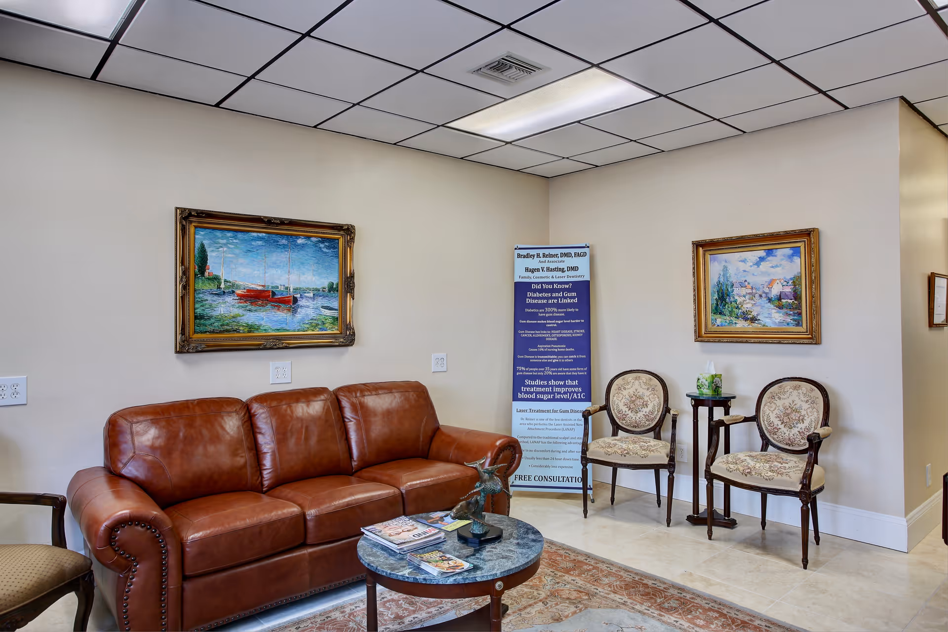 Waiting lounge with a brown leather sofa, two patterned chairs, and a coffee table.
