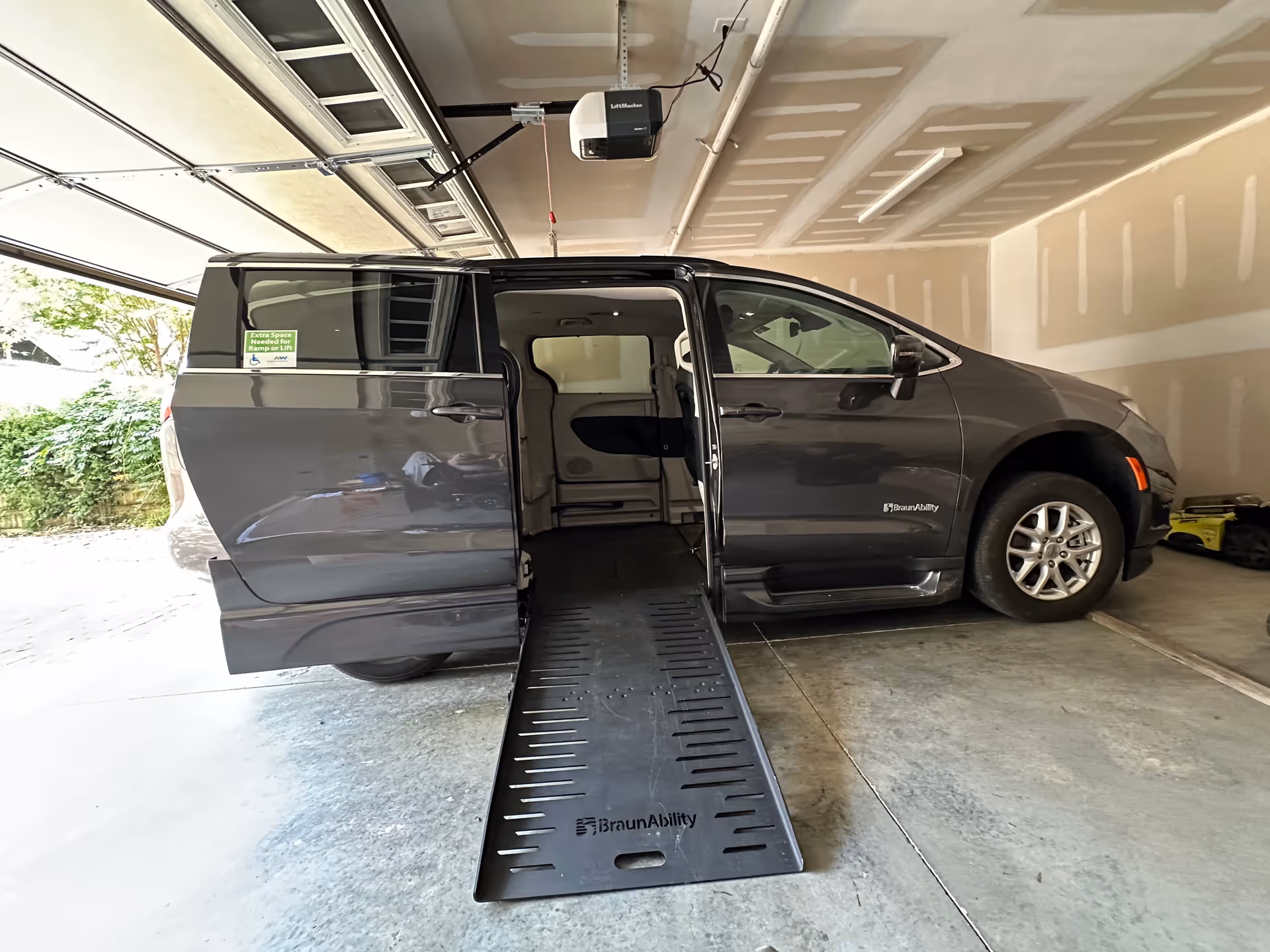 Gray BraunAbility wheelchair-accessible van with extended ramp inside a garage