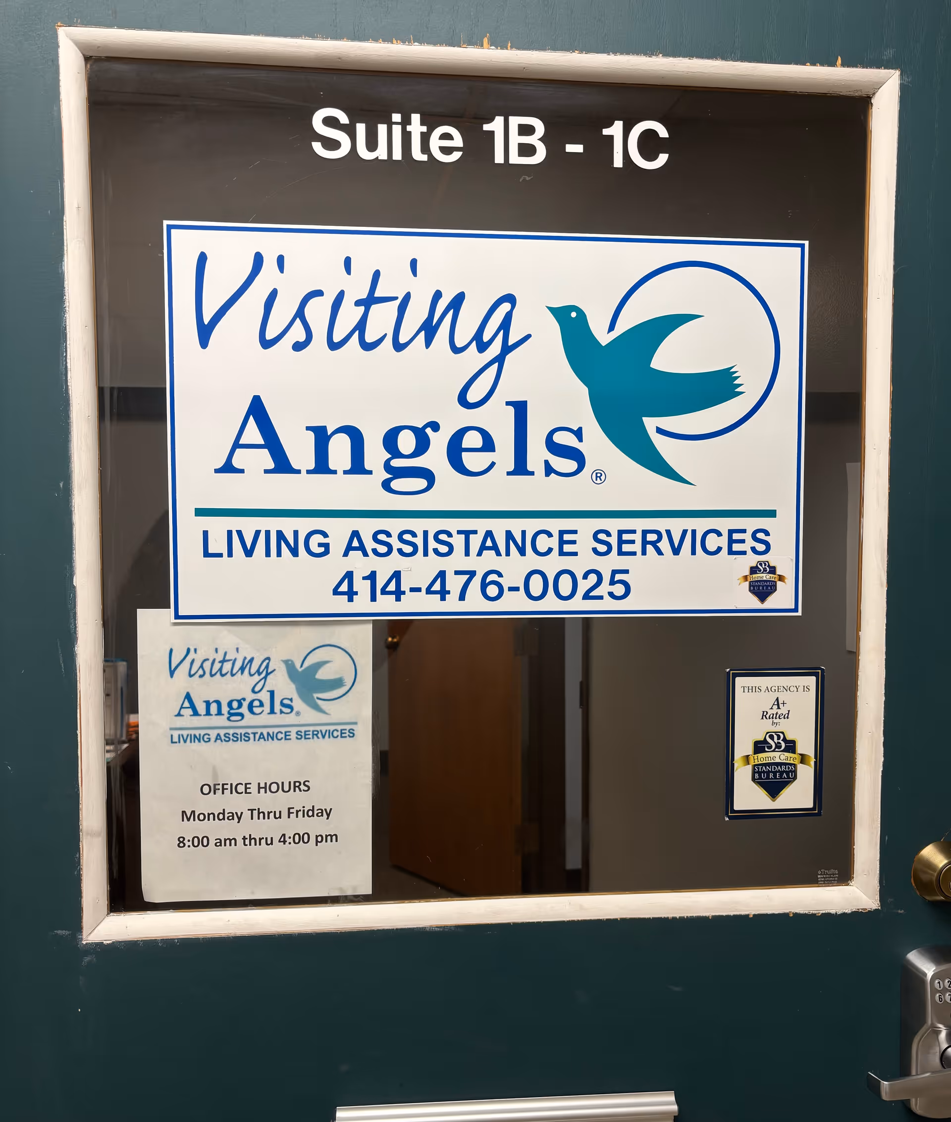 Door with Visiting Angels sign and office hours posted.