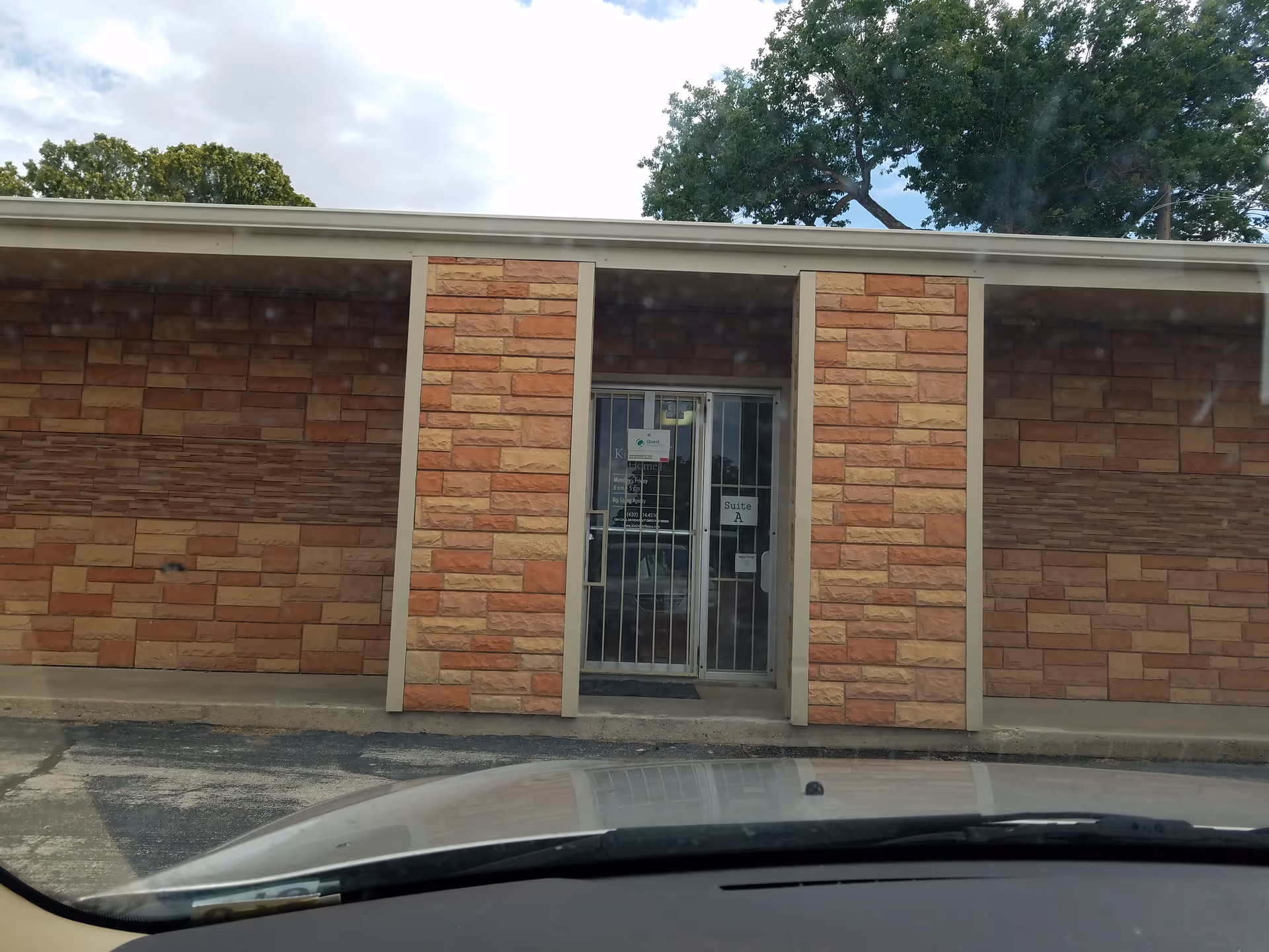 Brick exterior entrance with a glass door framed by brick columns.