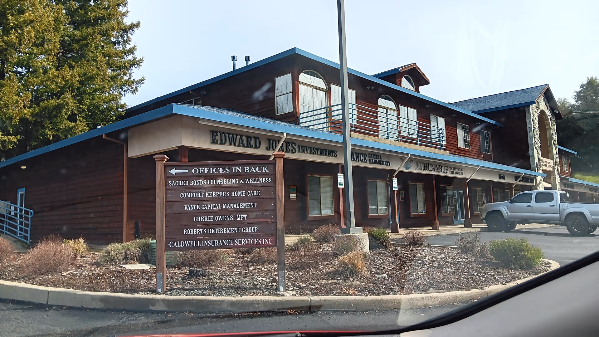 Exterior view of a wooden, multi-tenant building with Comfort Keepers Home Care signage.