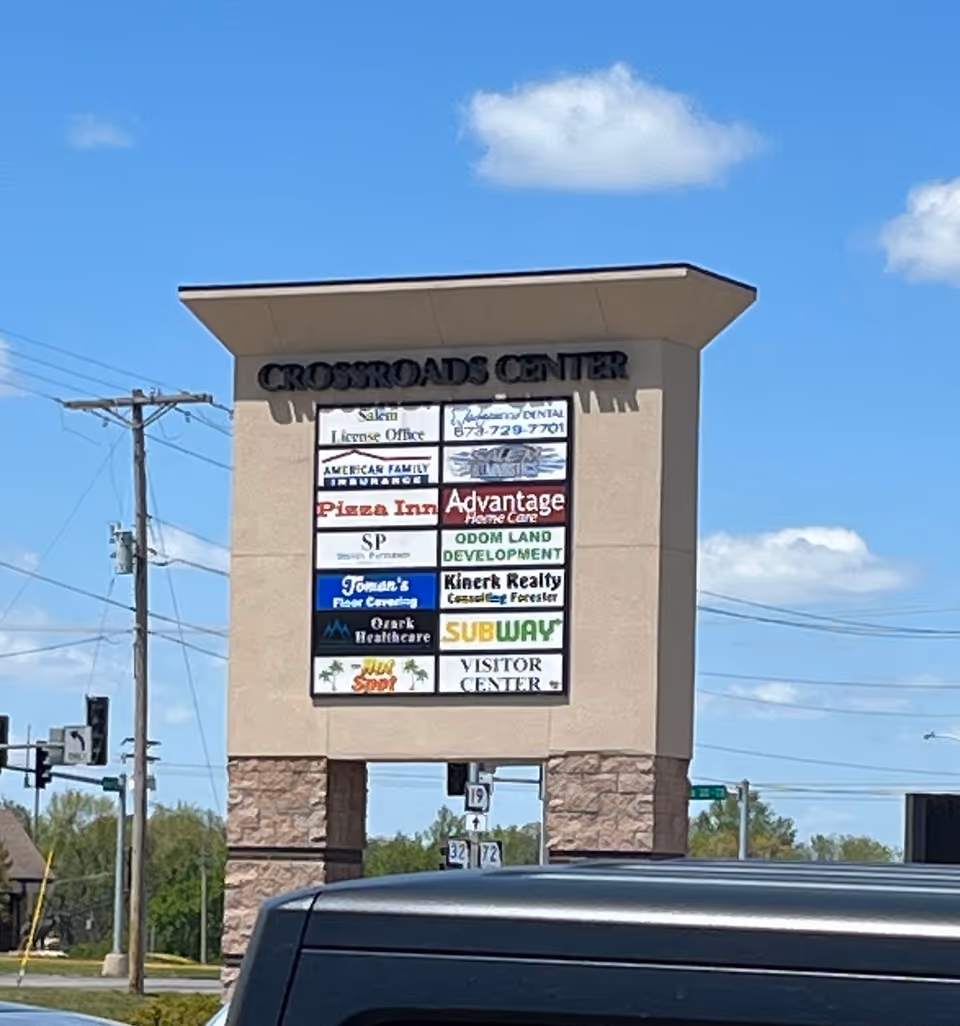 Outdoor Crossroads Center sign featuring Advantage Home Care among other business logos.