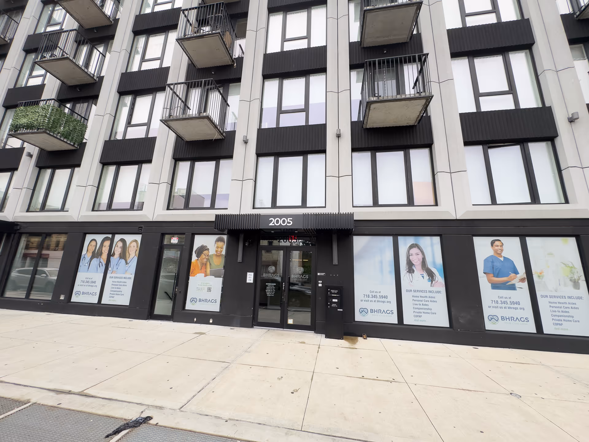 Modern multi-story building facade with large windows and BHRAGS Home Care signage.