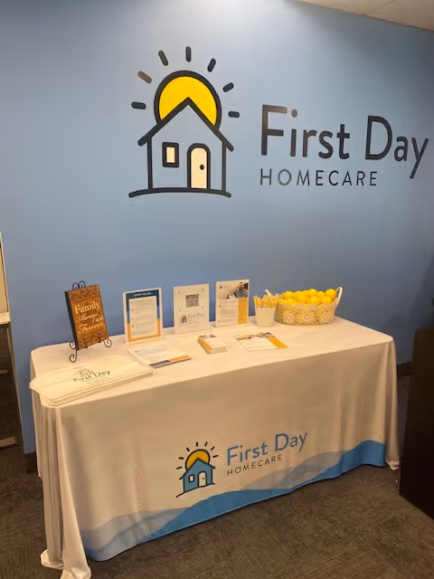 Reception desk with First Day Homecare logo on blue wall, brochures and basket of lemons.