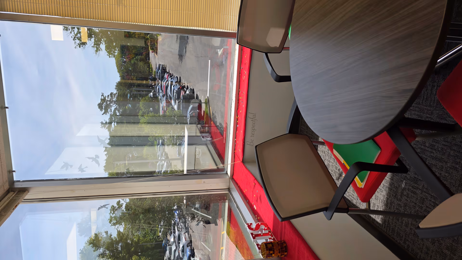 Indoor seating area with round table and chairs beside a large window.