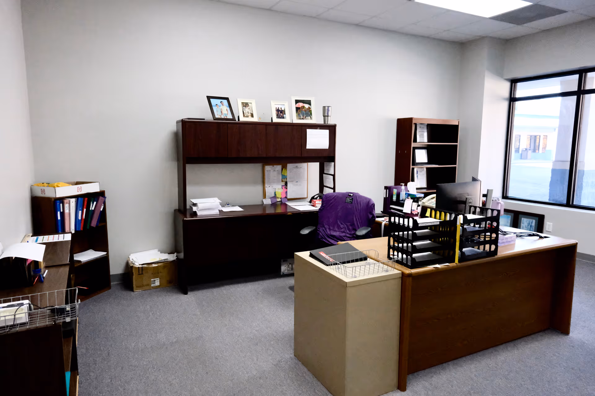Office workspace with desks, filing shelves, and documents in a senior care facility.