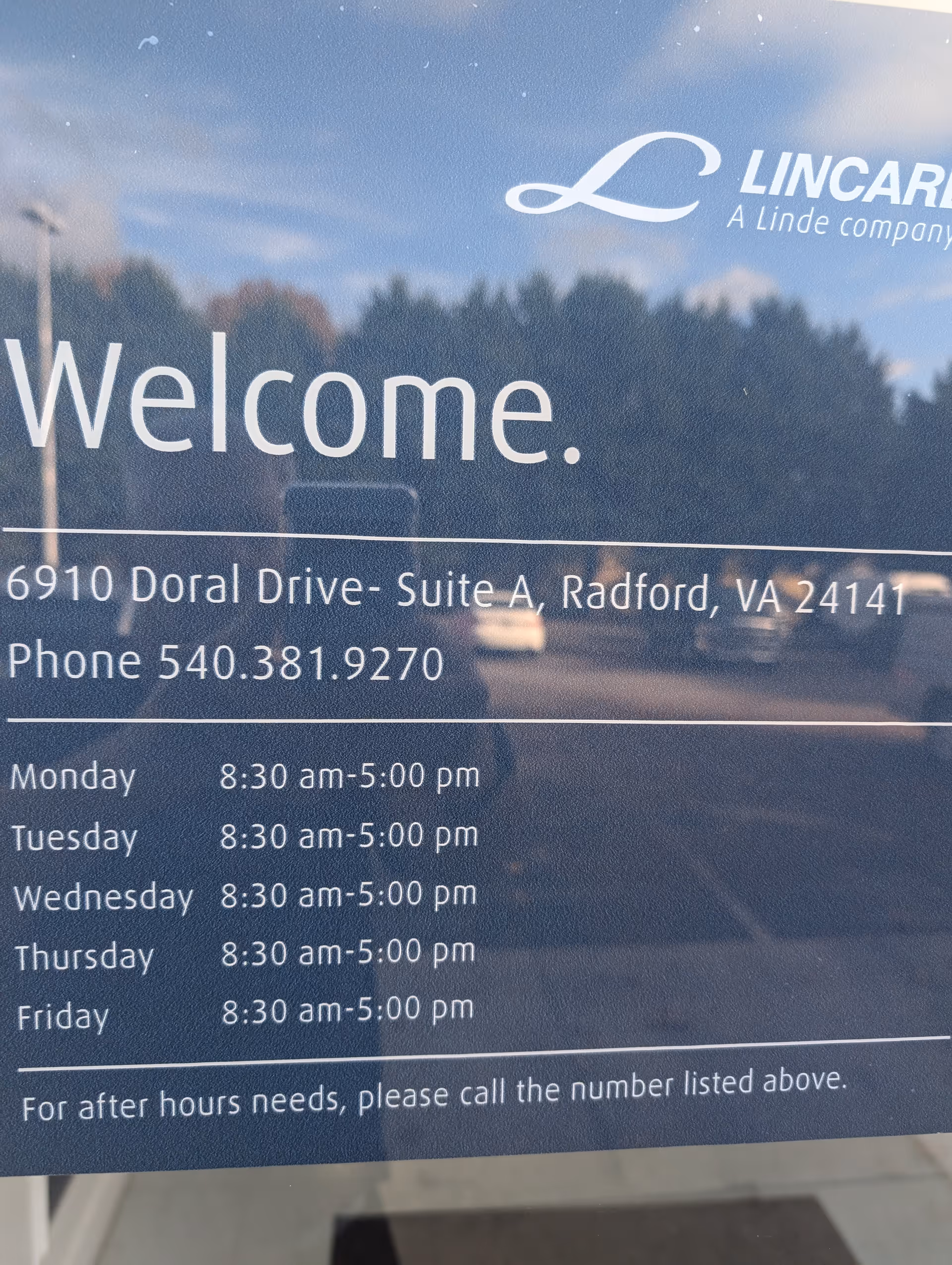 Reflection on glass sign reading Welcome with LINCARE logo, address, and hours.