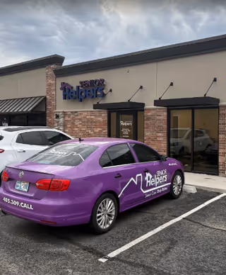 Front exterior of Senior Helpers facility with a purple company car in the parking lot.