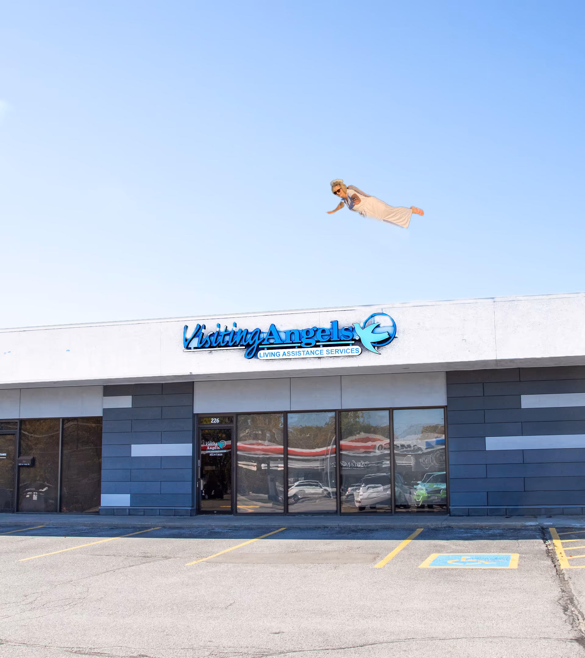 Exterior of Visiting Angels storefront with a person flying in the clear blue sky above.