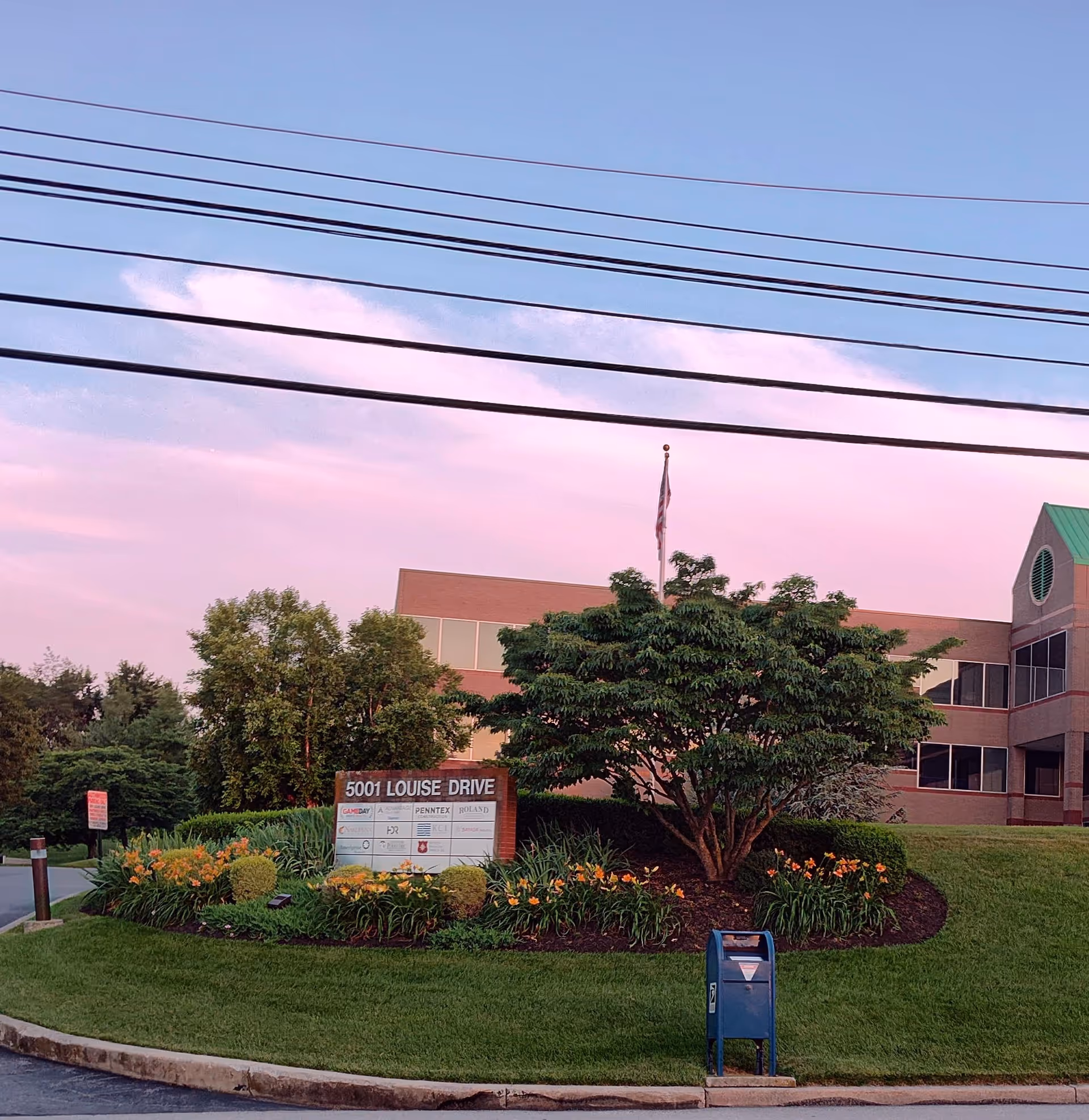 Exterior view of a medical facility with sign and landscaped grounds.
