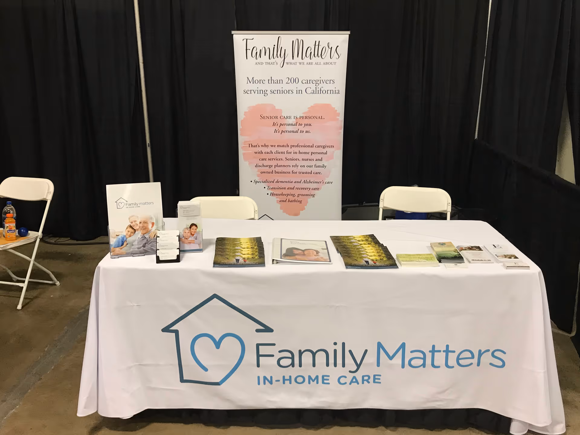 Table with brochures and a Family Matters In-Home Care banner at a booth.