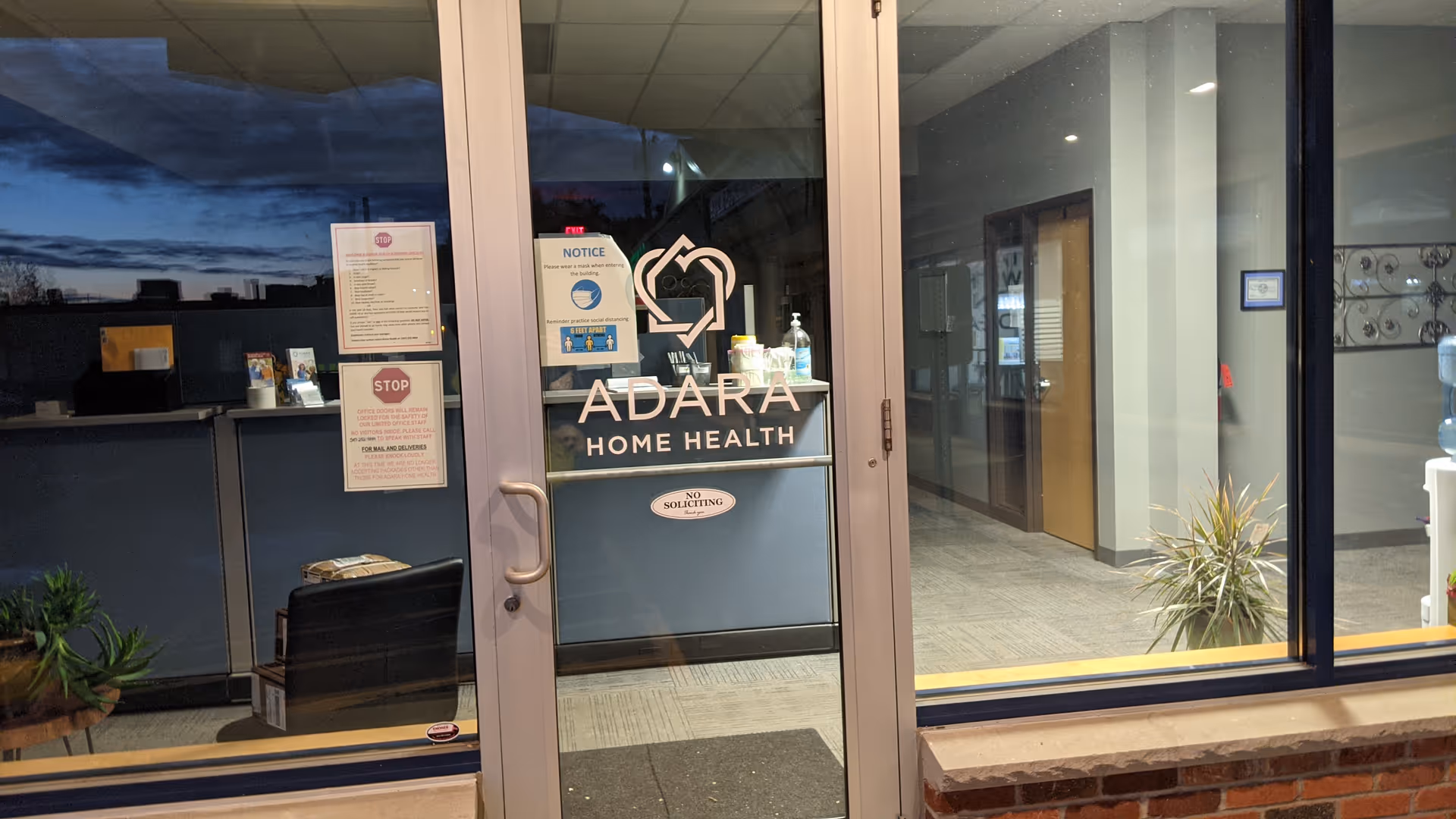Glass entrance doors showing the Adara Home Health sign and interior hallway.