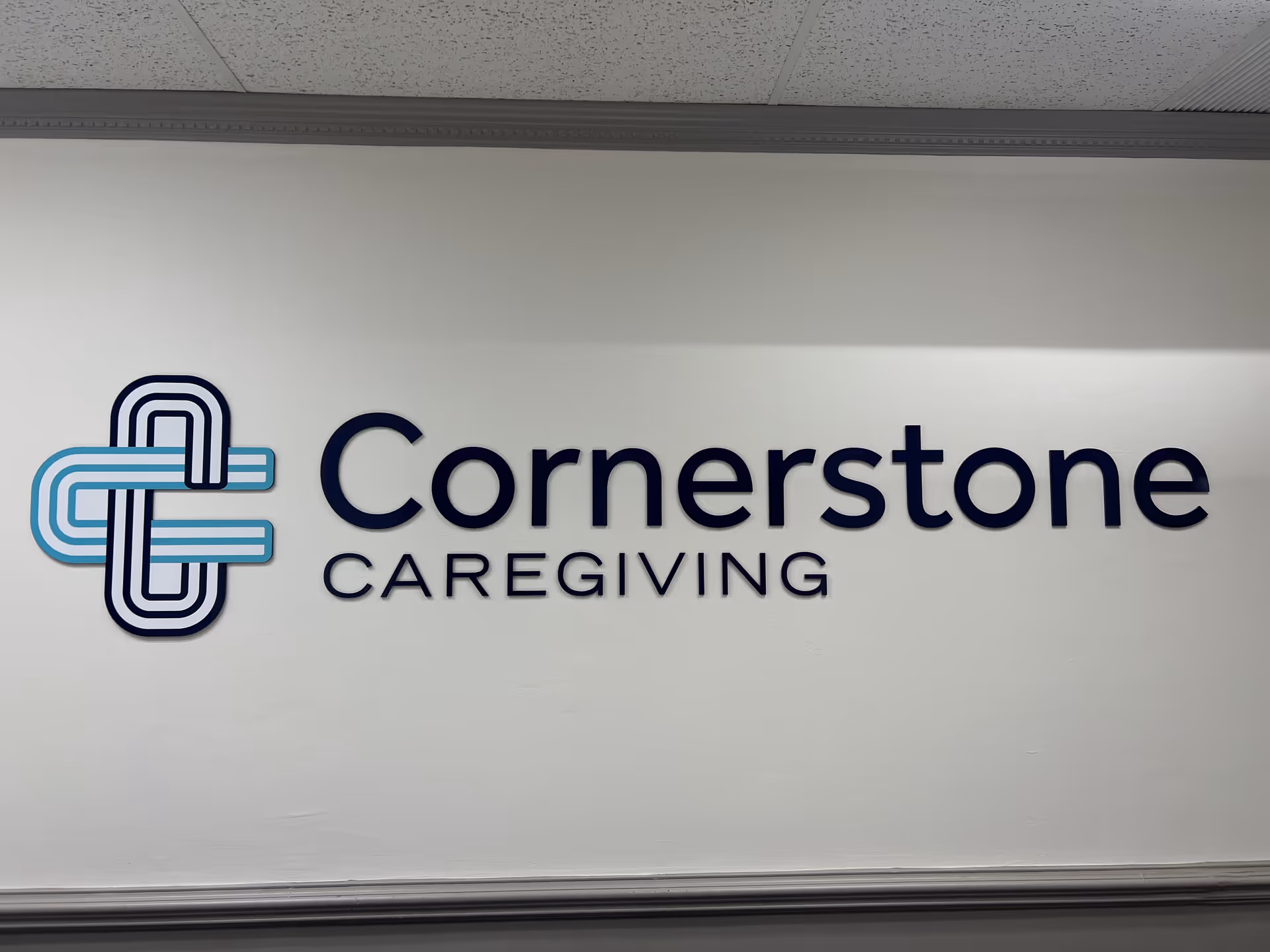 Interior wall showcasing Cornerstone Caregiving logo and signage in a hallway