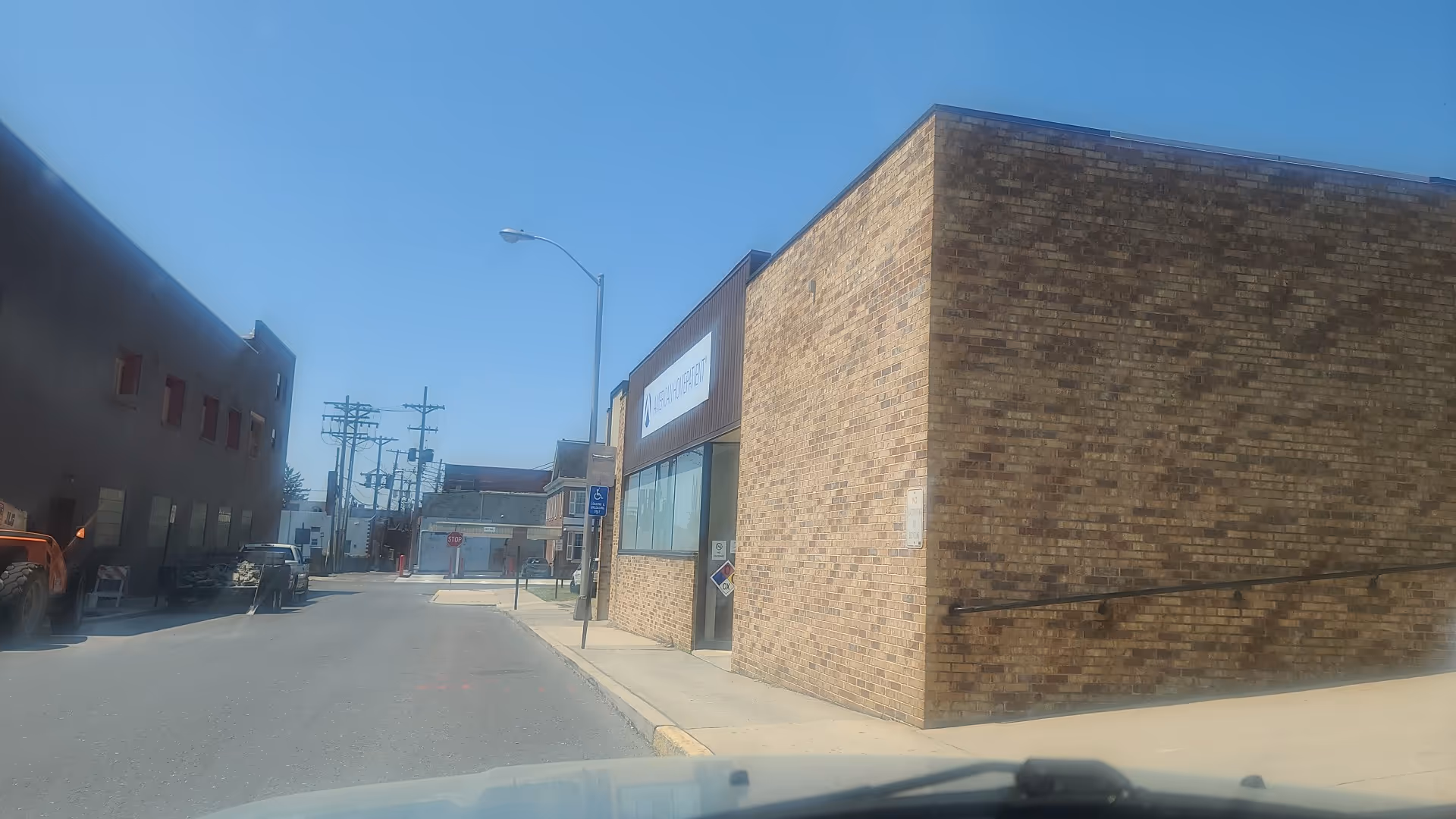 Exterior view of American HomePatient facility, a brick building along a sunny street.